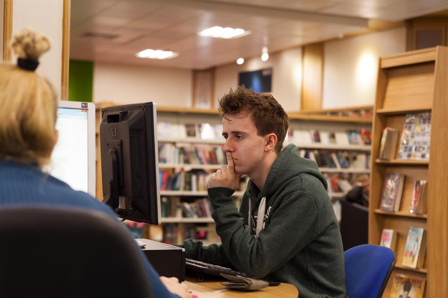 A man on a computer at a Lincoln library