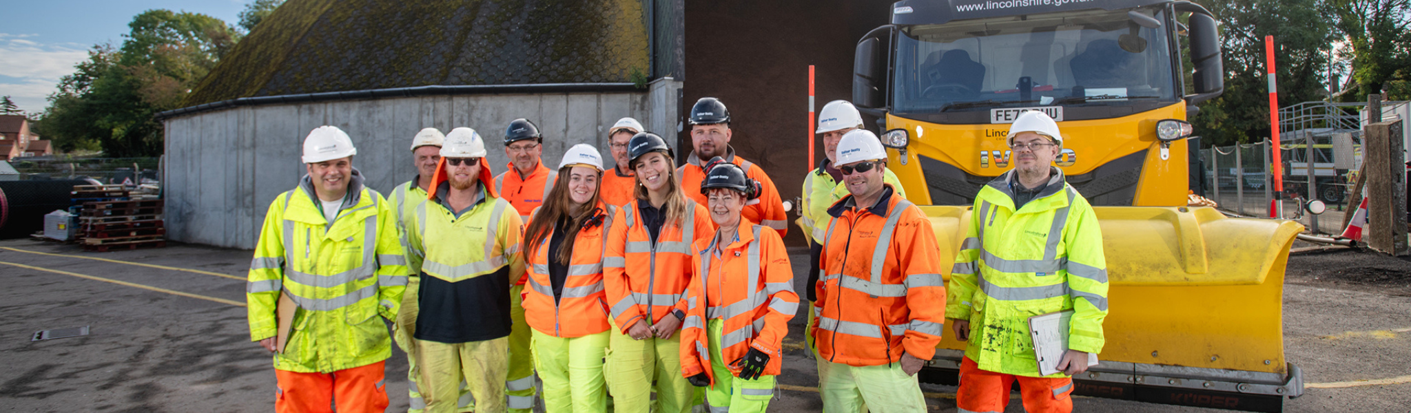 The council's grit team stood in high-vis in front of the county gritter.