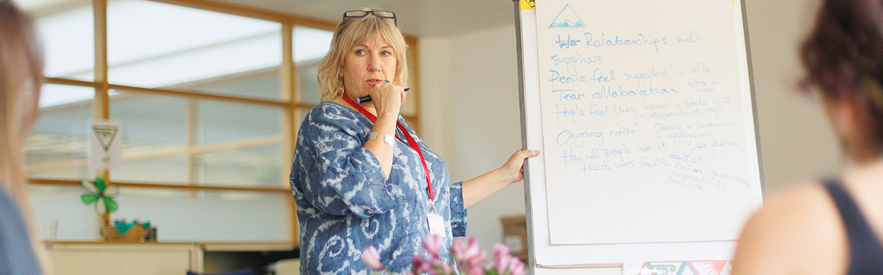 Image of a woman writing on a white board