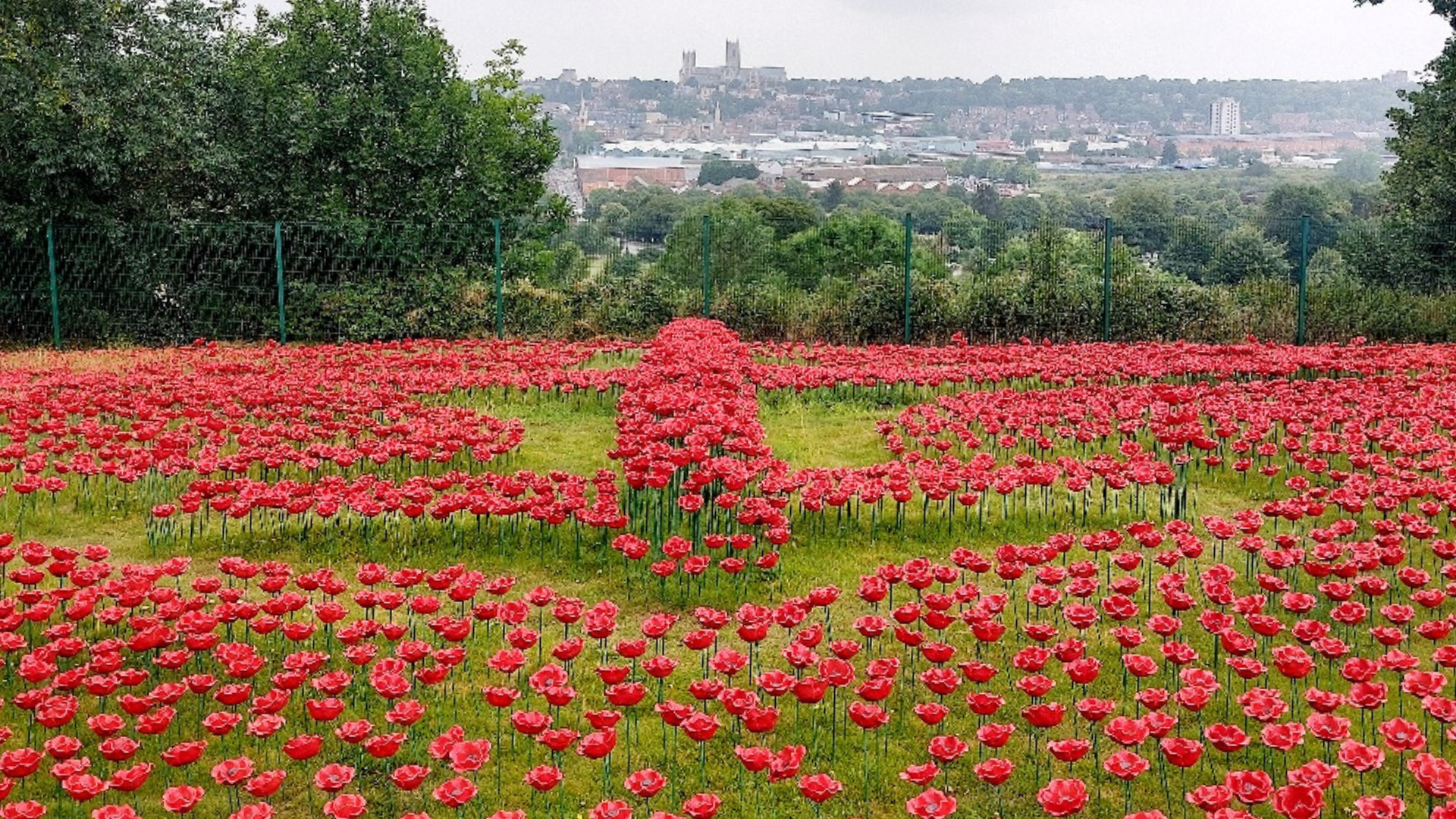 Lancaster Bomber recreated with poppies at International Bomber Command Centre in the foreground, with Lincoln's skyline, including Cathedral, from the south looking north in the background
