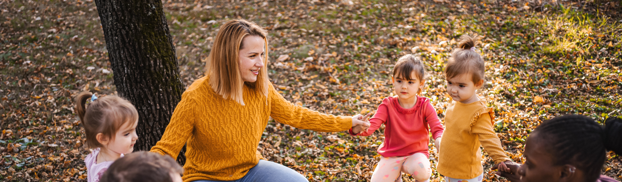 A mother kneeling down with two young children