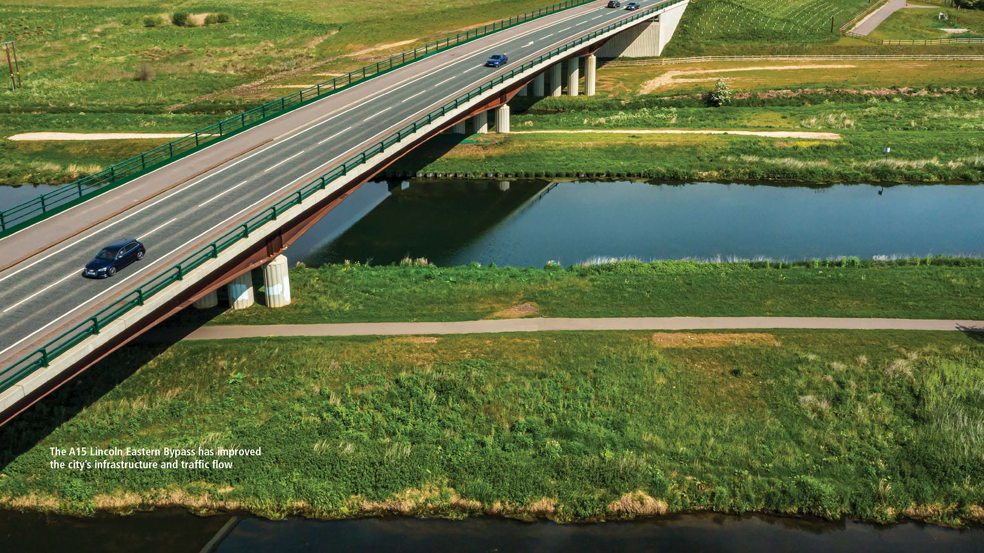 Aerial view of cars going over a bridge that spans two waterways