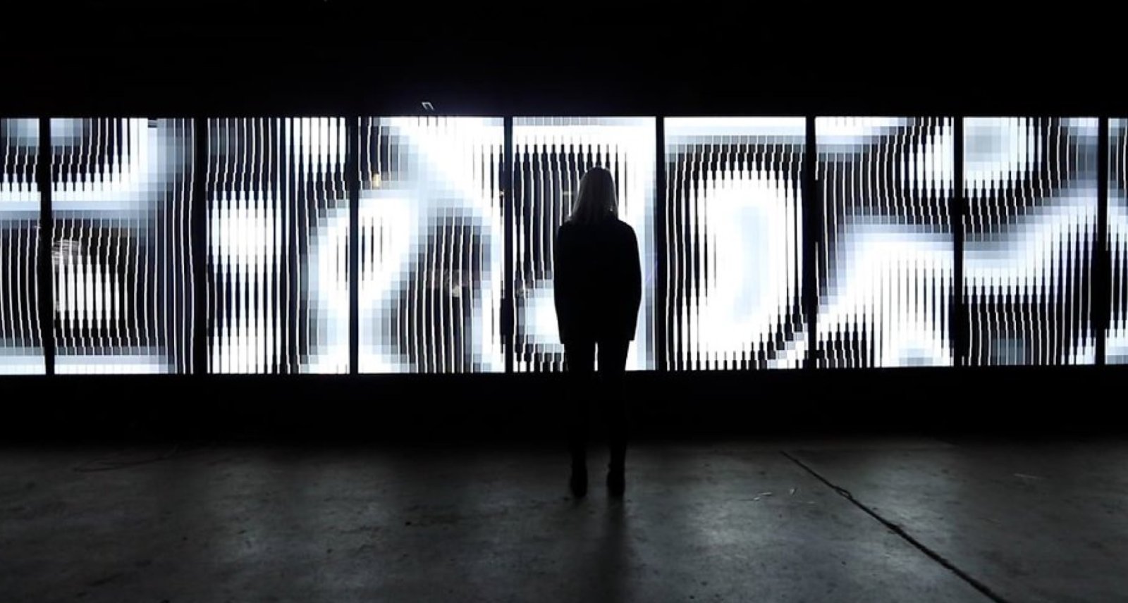 A woman stood in front a light installation