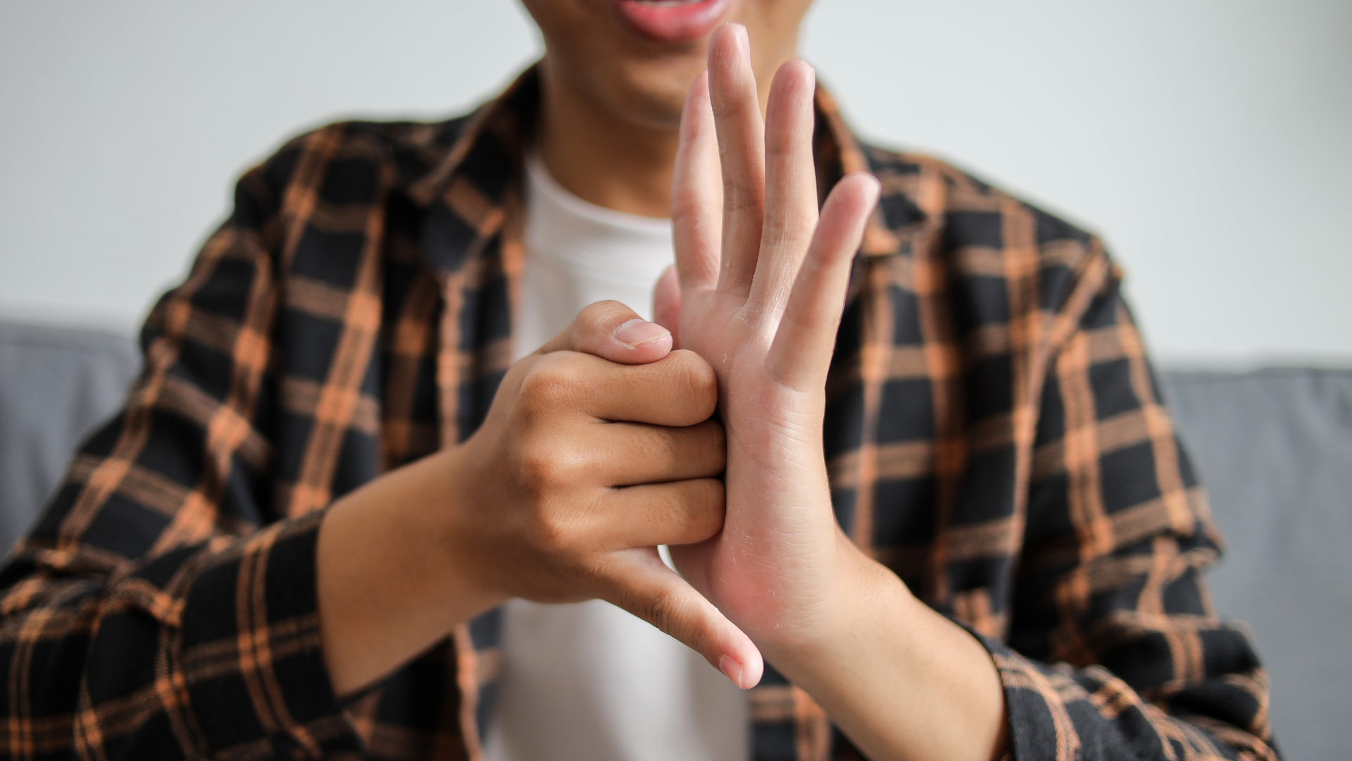 Close up of man's hands doing a sign in british sign language