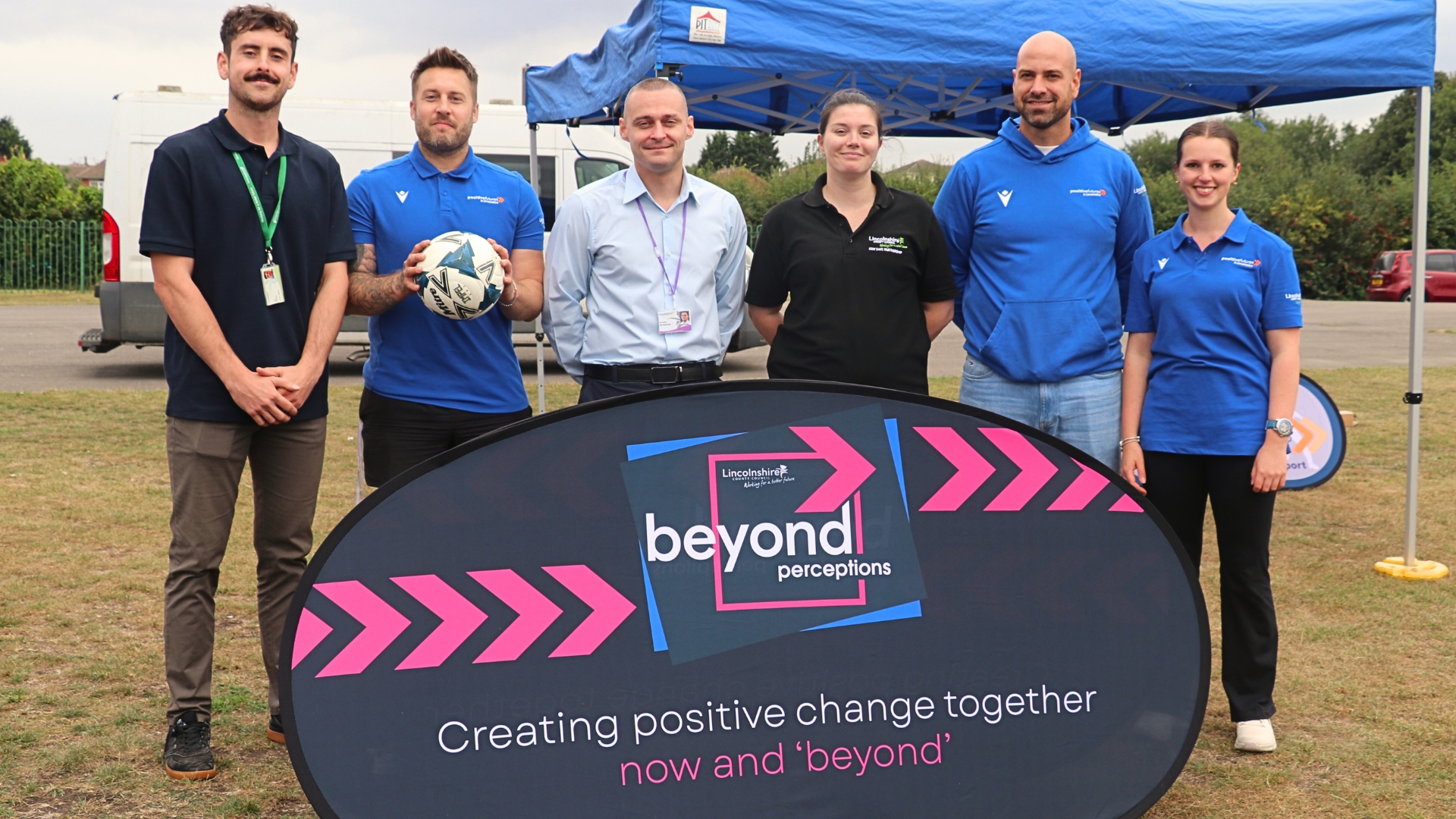 Cllr Alex McGonigle, executive member for community safety at Lincolnshire County Council, pictured with council staff at a 'Beyond' park day in Gainsborough. They are stood in front of a banner reading "Creating positive change together, now and 'beyond'