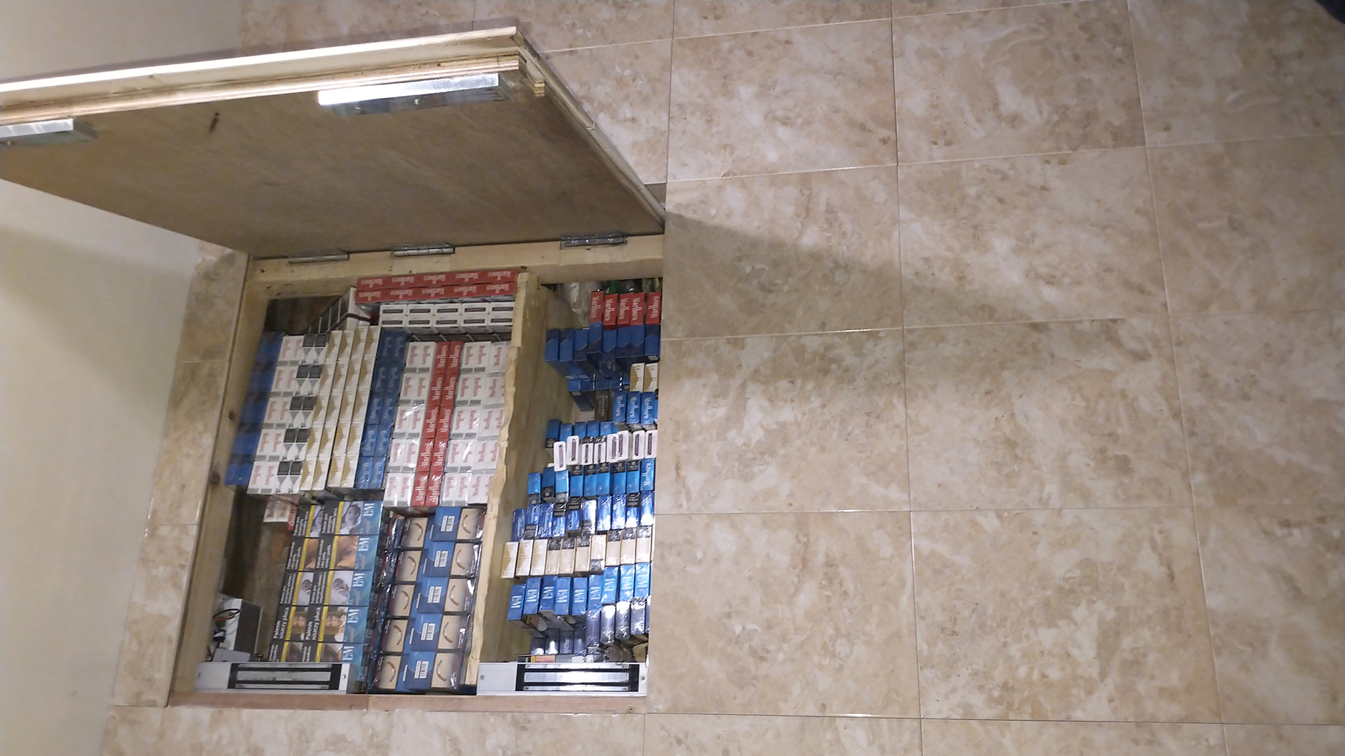 An image of the secret hiding place for illicit items, amongst normal floor tiles.