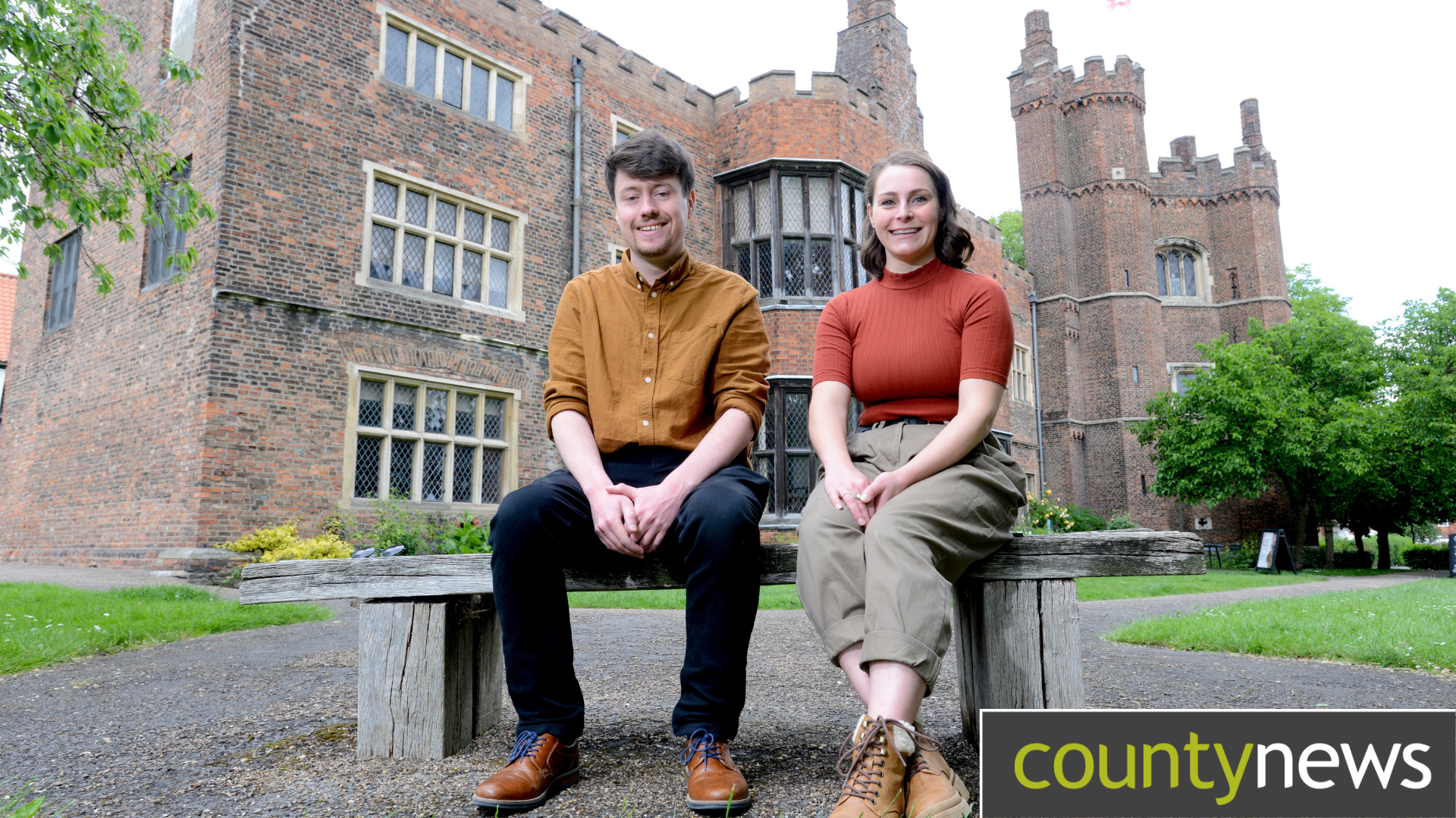 Two people sat on a bench outside Gainsborough Old Hall