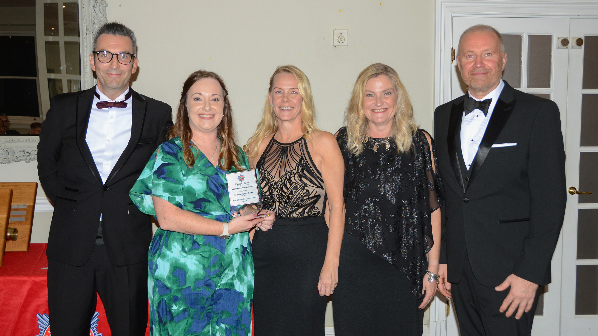 Five people posing with award