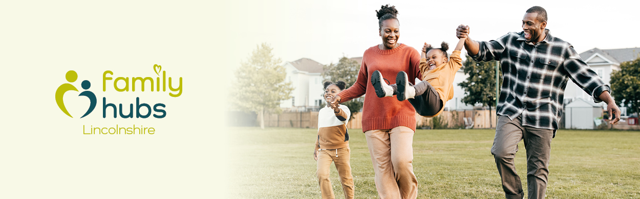 A family walking a field with their daughters swinging on their arms. On the left reads Family Hubs