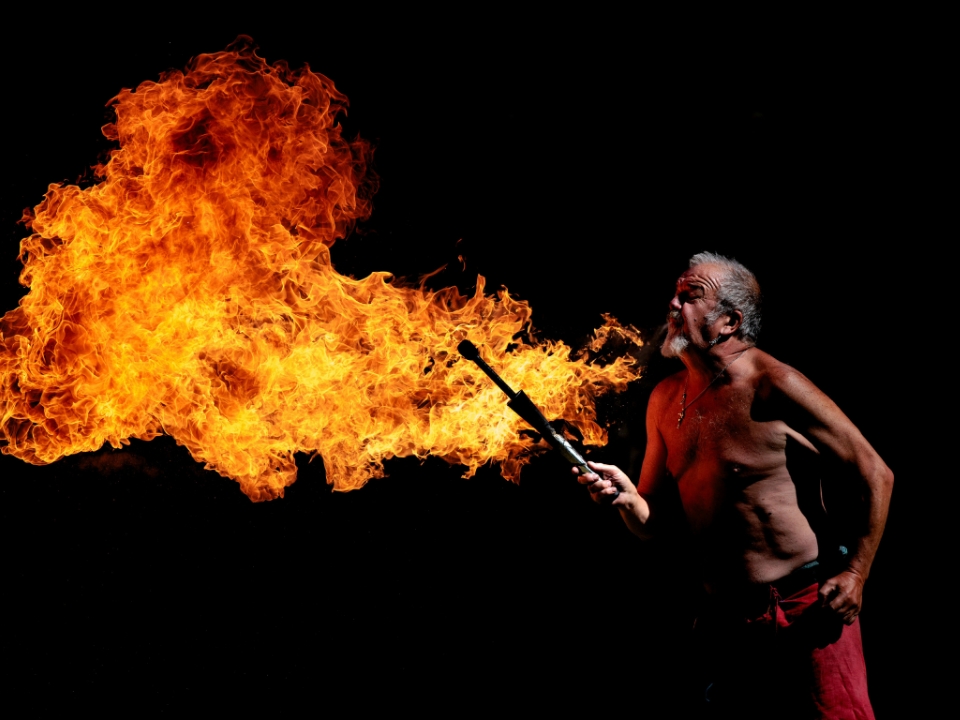 A man blows fire. See jaw-dropping stunts from What a Palaver during the Festival of History