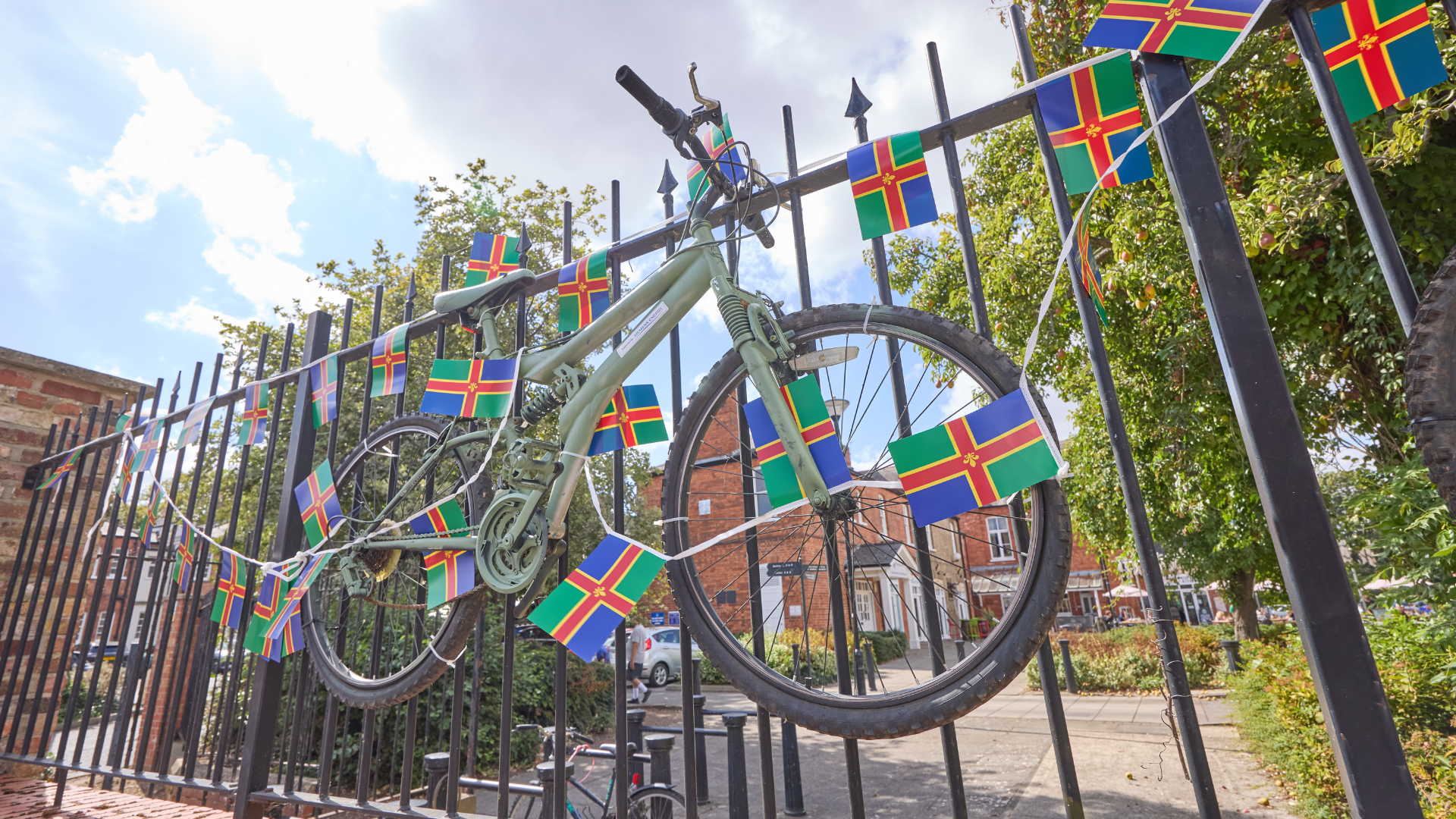 green bike on fence with lincolnshire flags