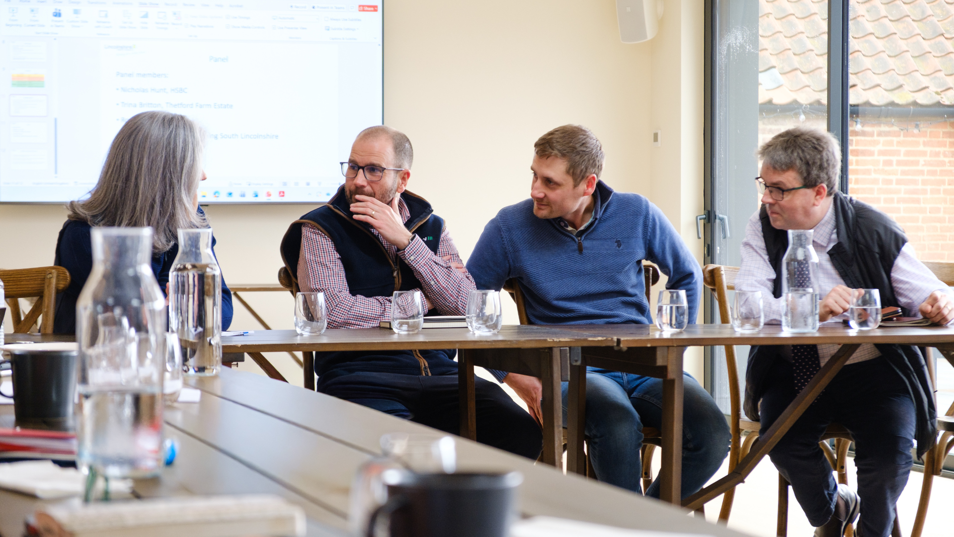 four panel members in discussion at top table