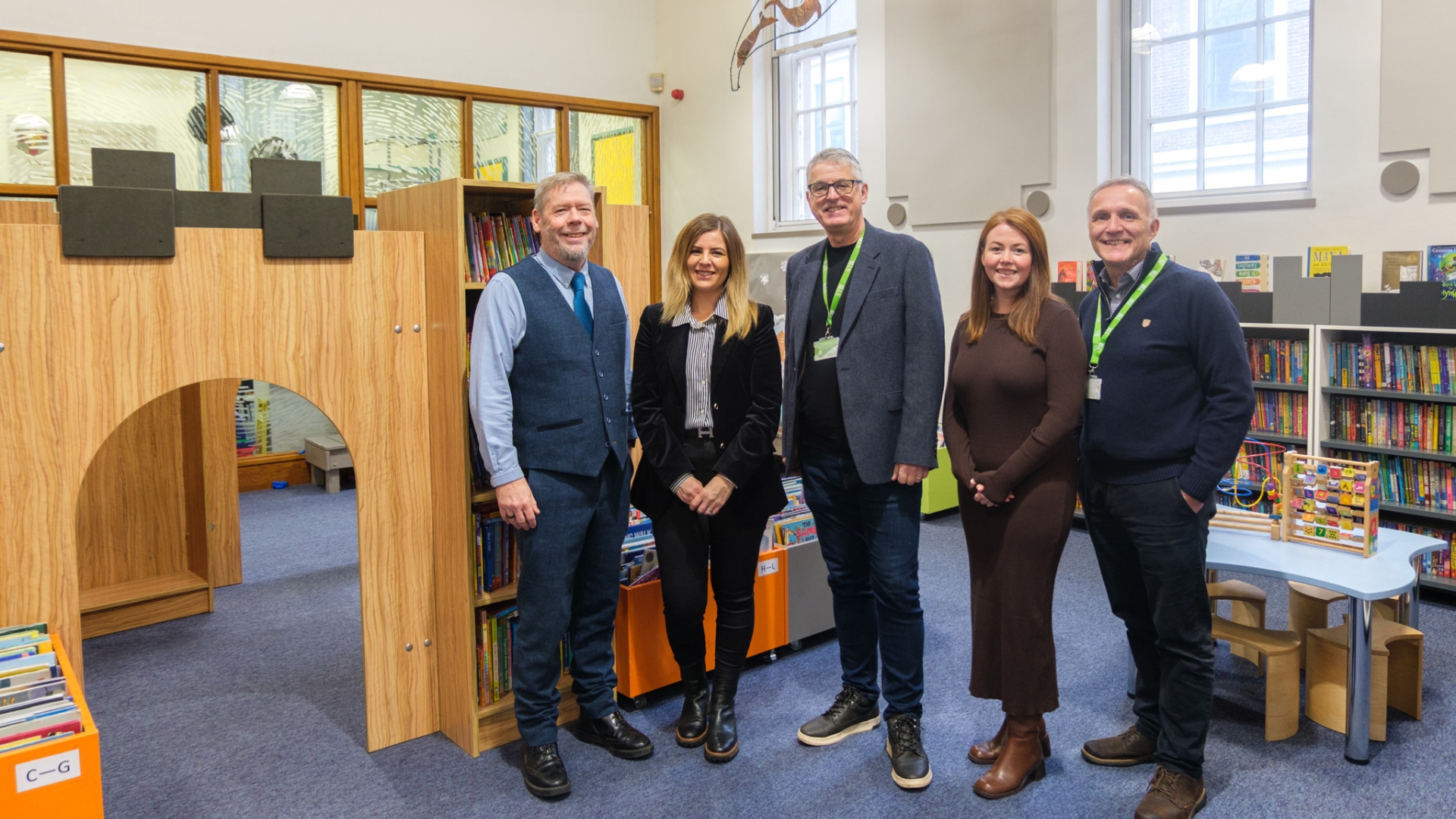 Senior managers from GLL and Lincolnshire County Council pictured with Cllr Natalie Oliver. They are standing next to a wooden castle in the children's area of Lincoln Central Library