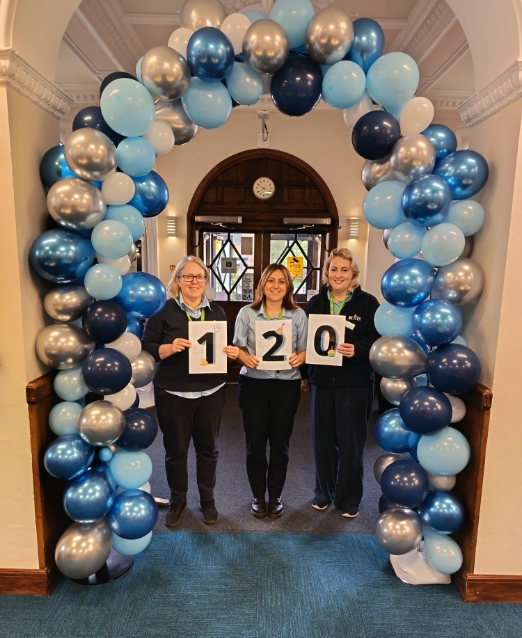The Lincolnshire Libraries team are pictured holding cards reading "120" to celebrate 120 years of Gainsborough Library. They are surrounded by a balloon arch