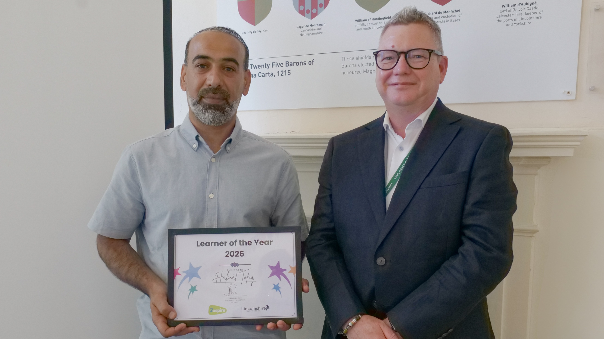 two men posing with certificate