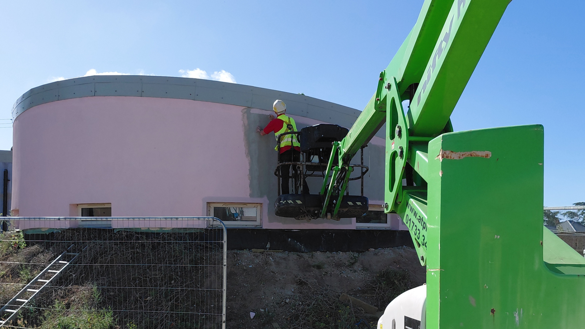Contractor refurbishing the lime render of a business unit