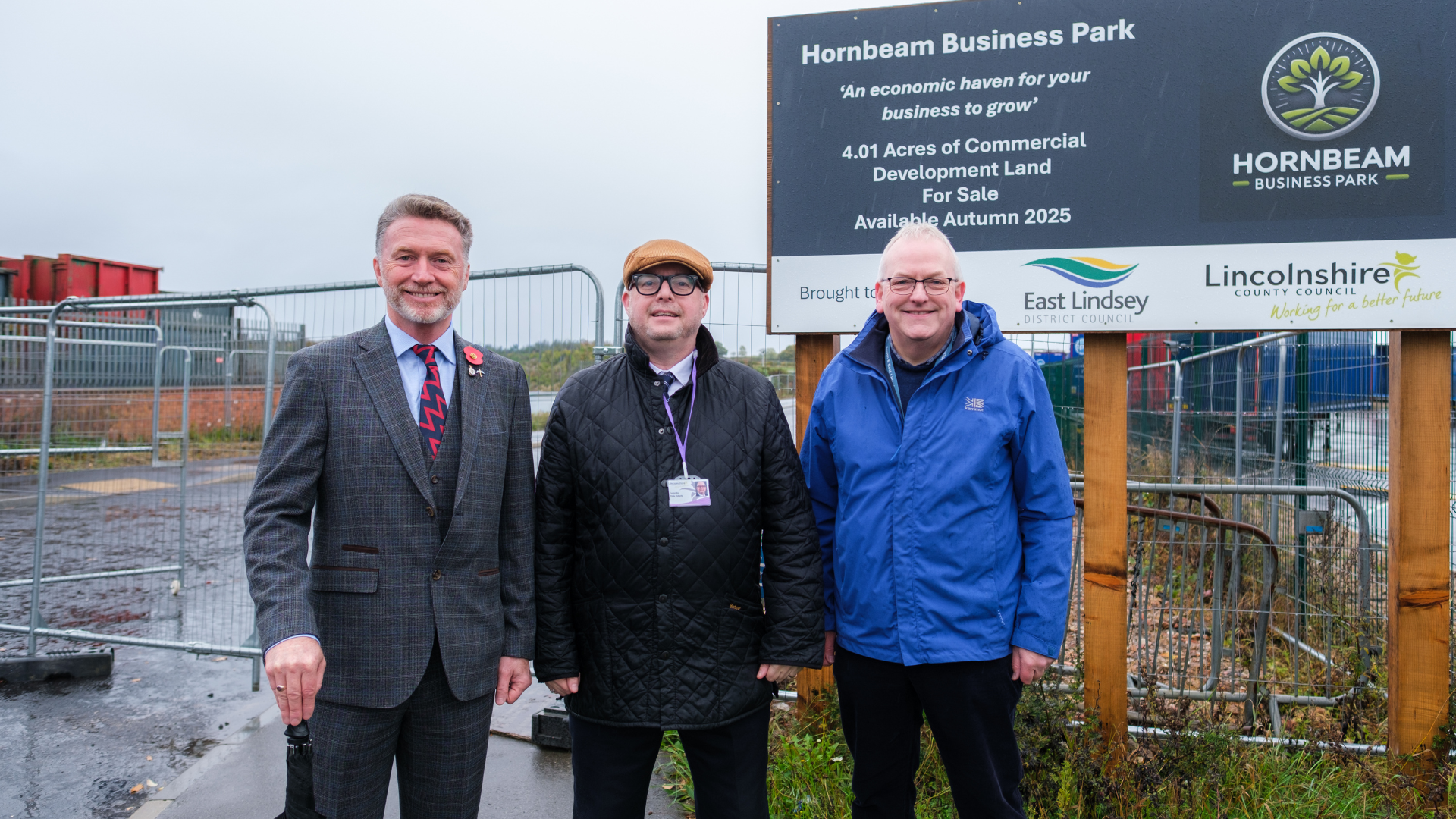 three councillors in front of the hornbeam business park sign