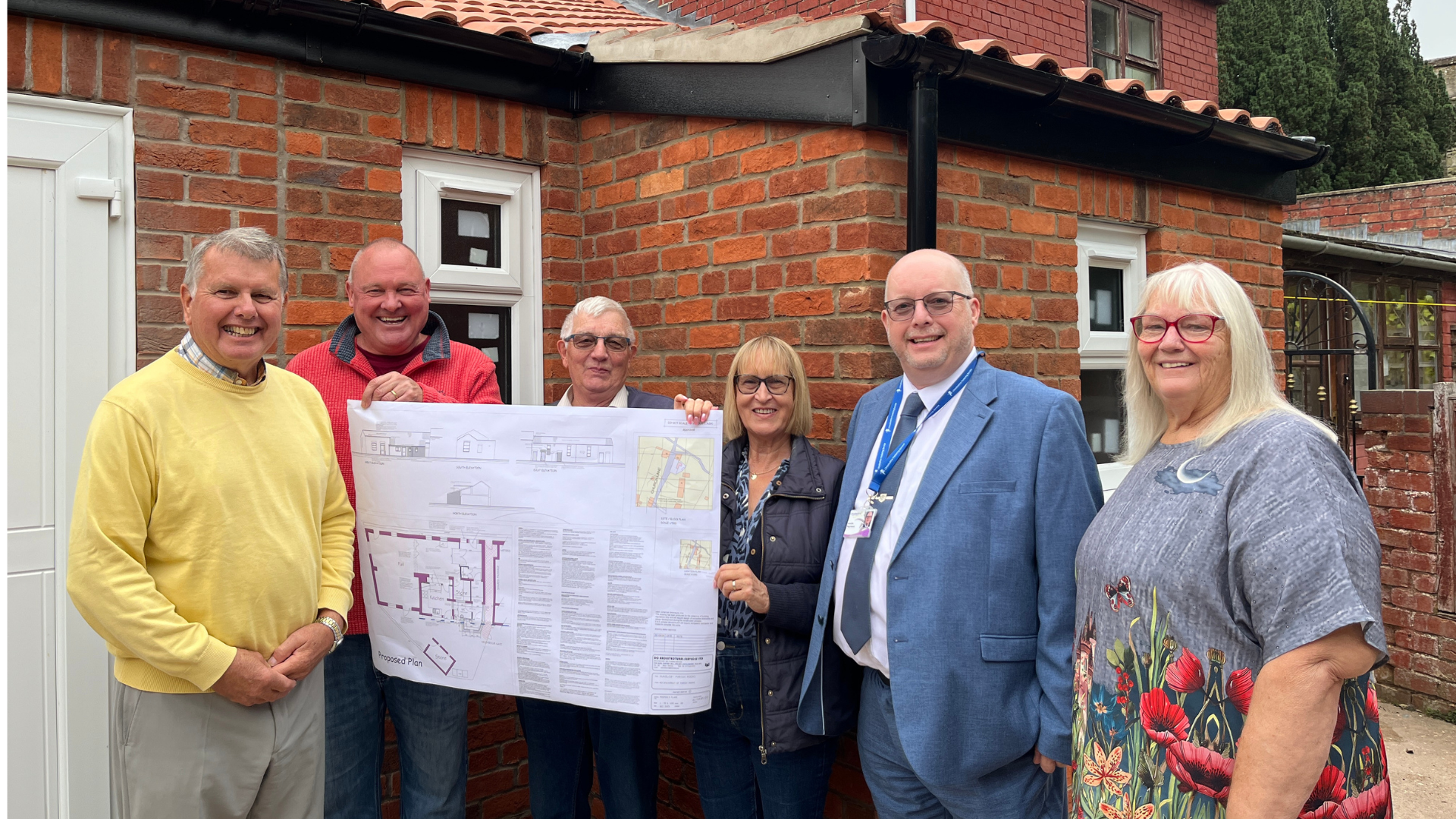 Members of Hundleby Parish Council with county councillor Philip Roberts and a large scale architectural plan of the Parish Rooms