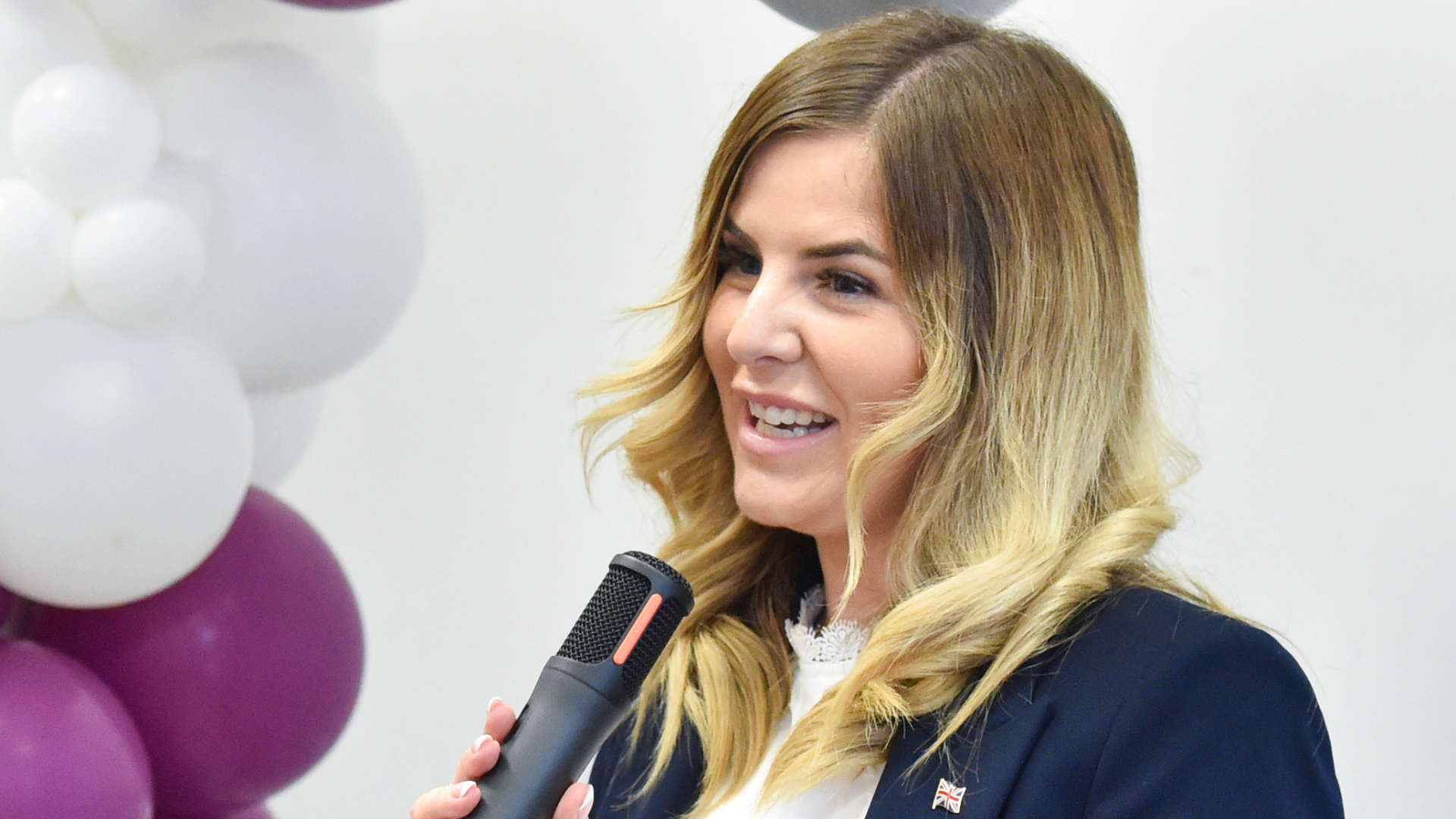 Cllr Natalie Oliver standing with a microphone in her hand