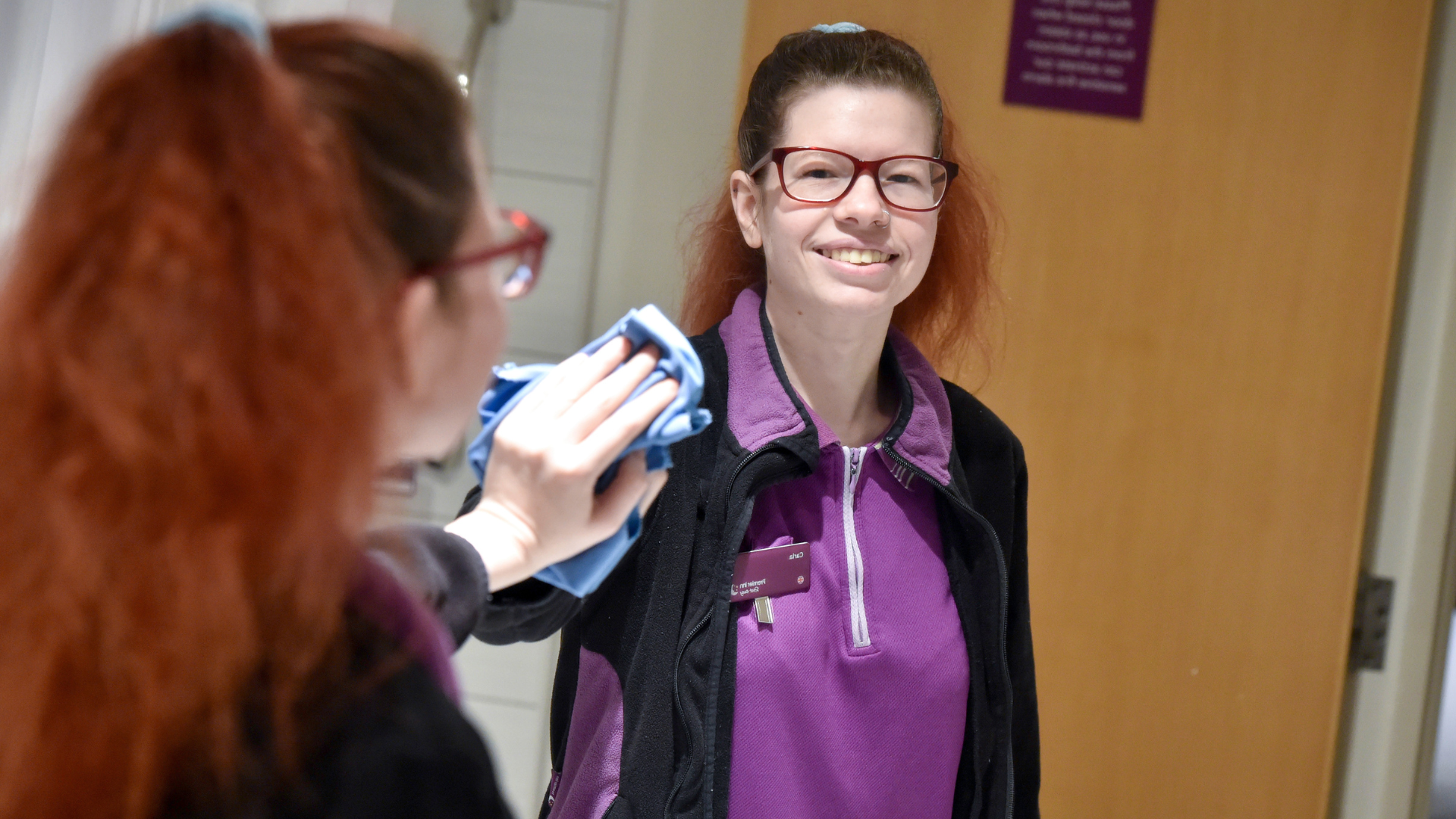 Carla looking into a mirror whilst cleaning