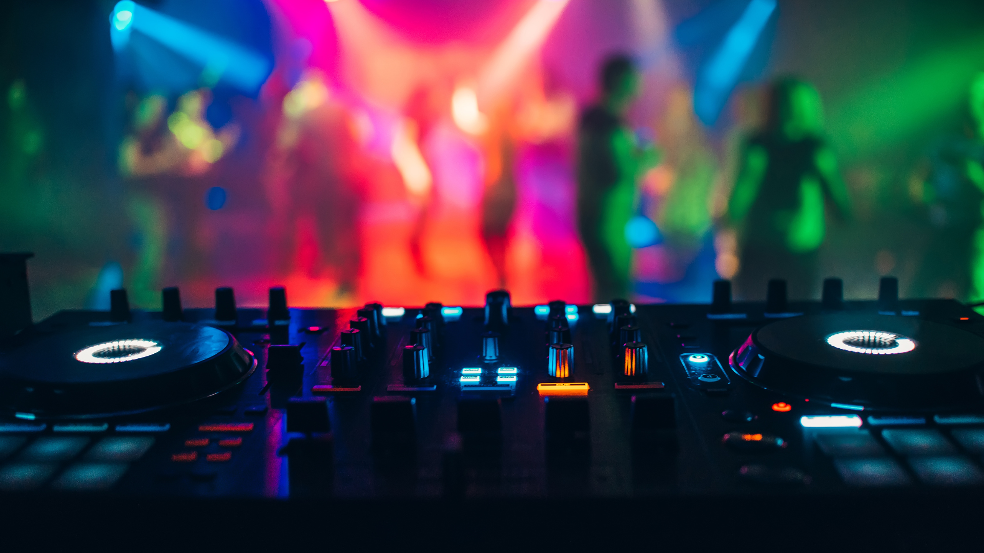DJ decks in front of colourful dancefloor