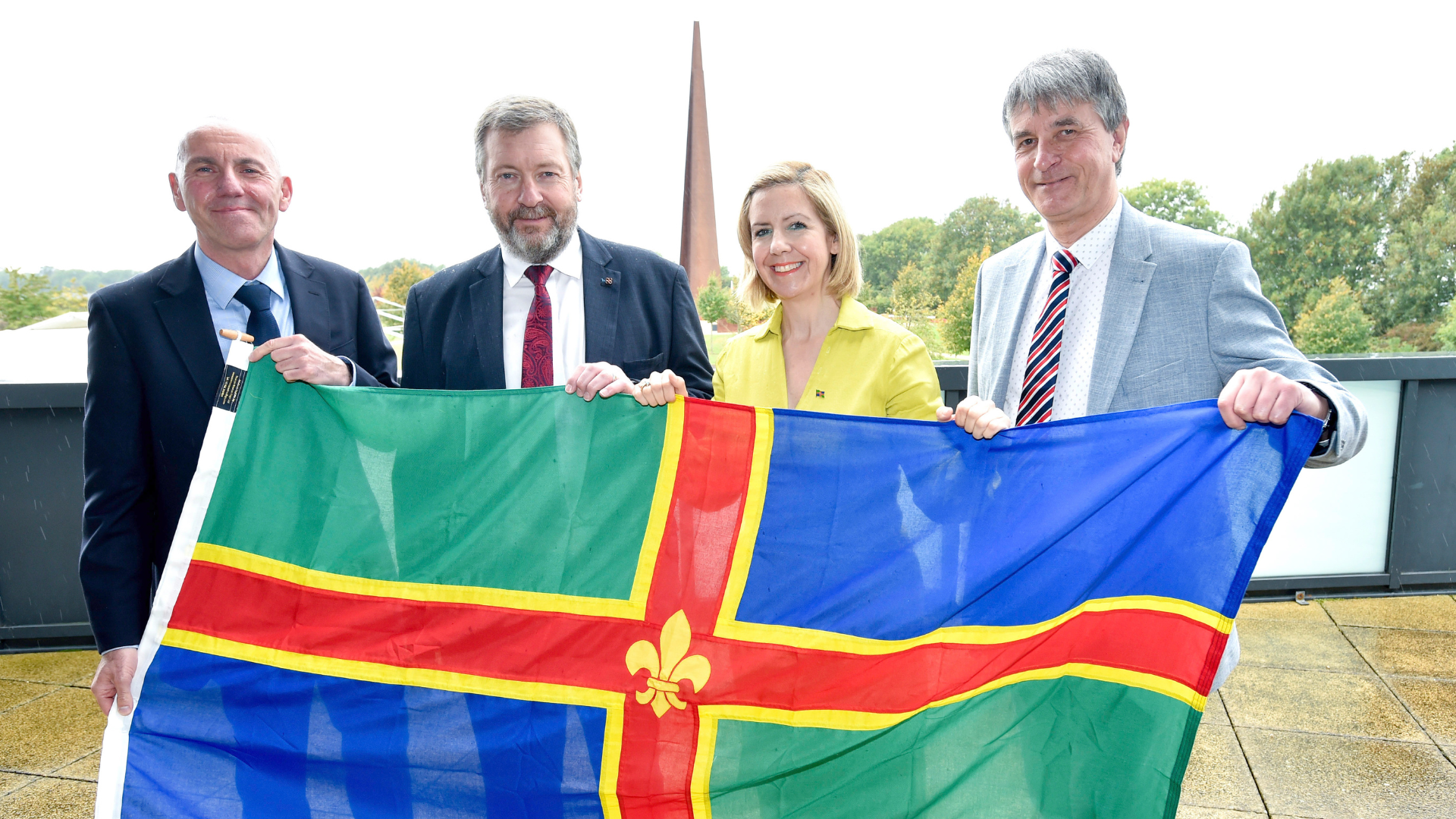 Rob Waltham, Sean Matthews, Andrea Jenkyns and Philip Jackson with the Lincolnshire flag