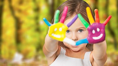 Child holding up their colourful, painted hands