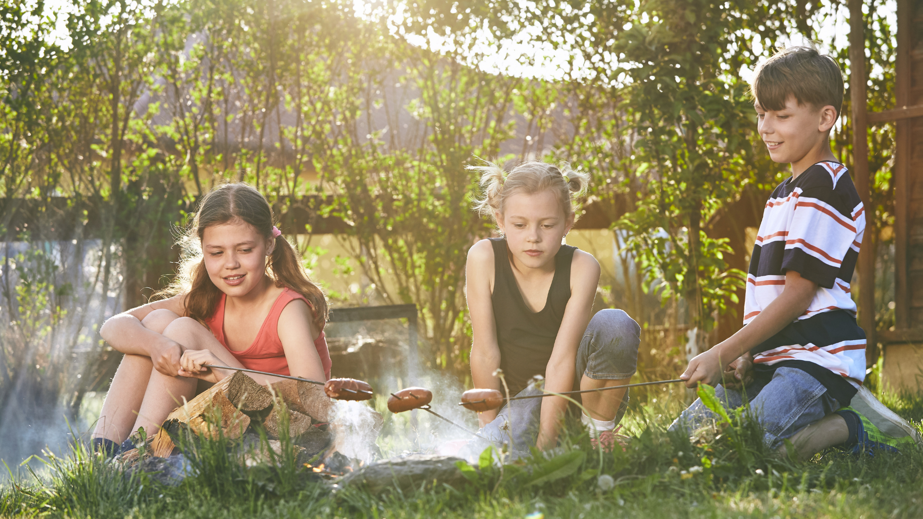 Three children enjoy a campfire