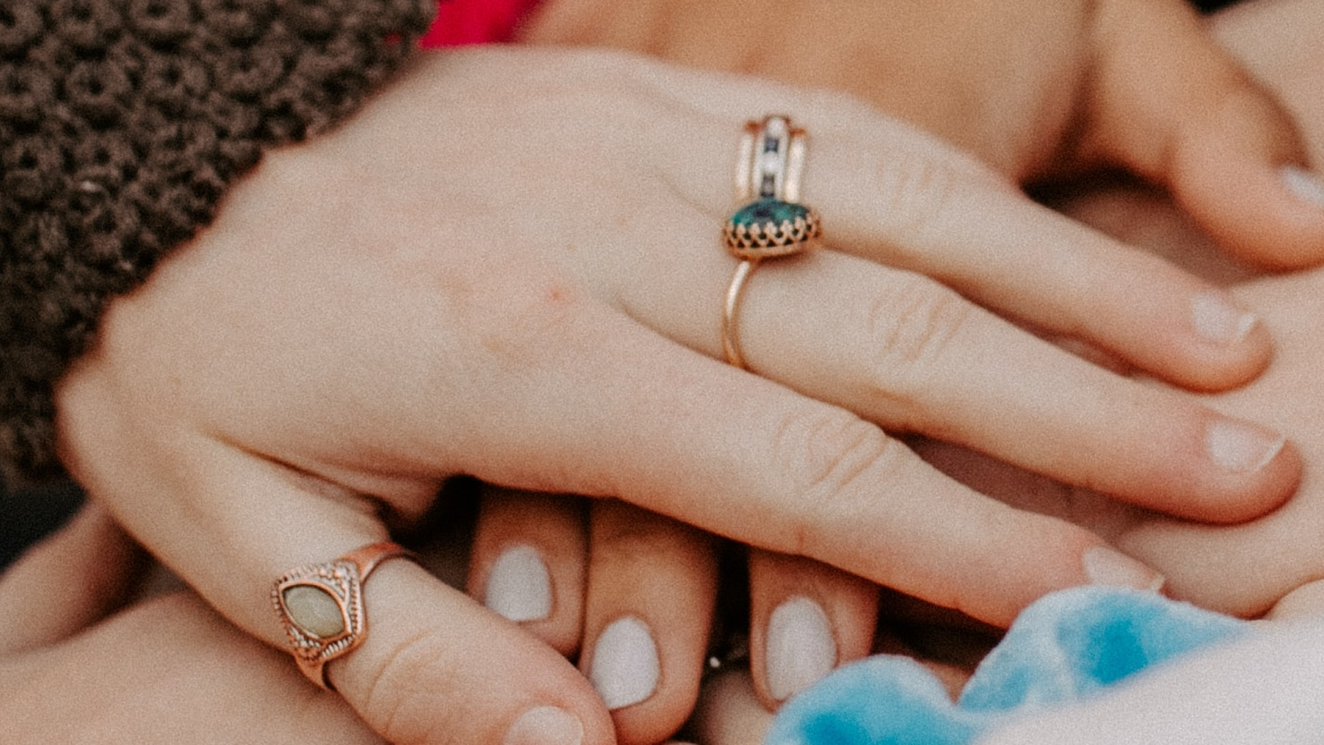 Three hands stacked on top of each other to show support