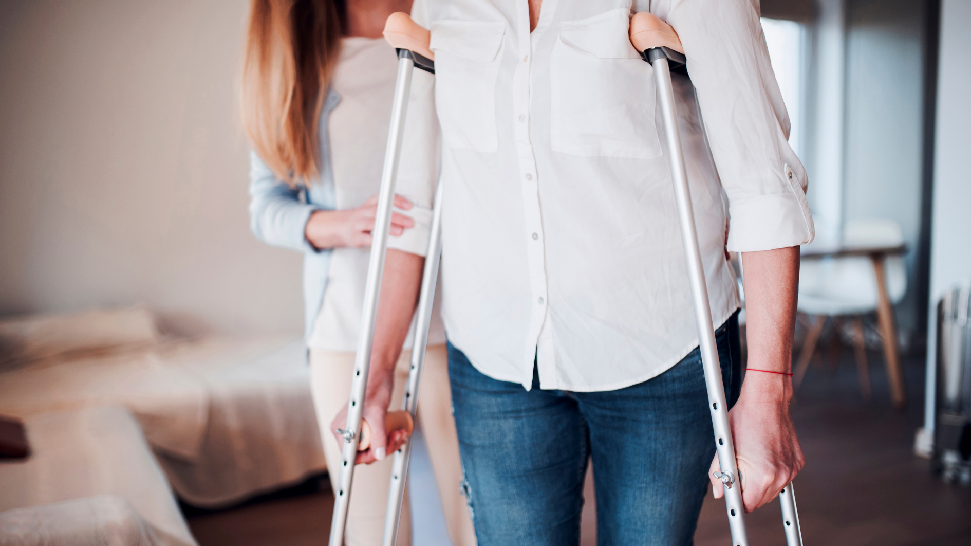 Daughter helping mother on crutches