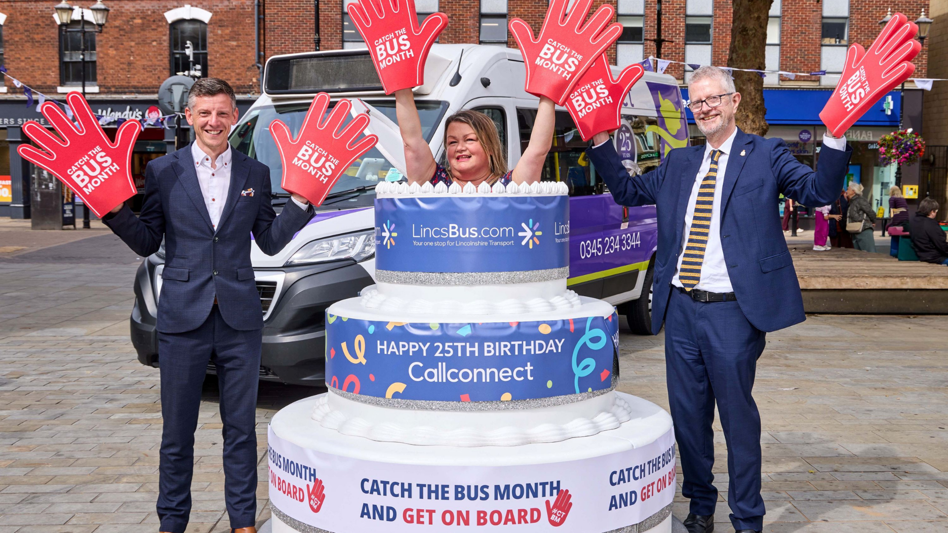 two men with foam hands either side of woman appearing from a cake with happy 25th birthday Callconnect