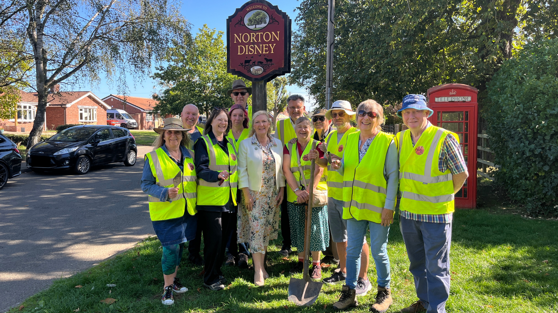A group of volunteers in high viz jackets with their local county councillor Marianne Overton