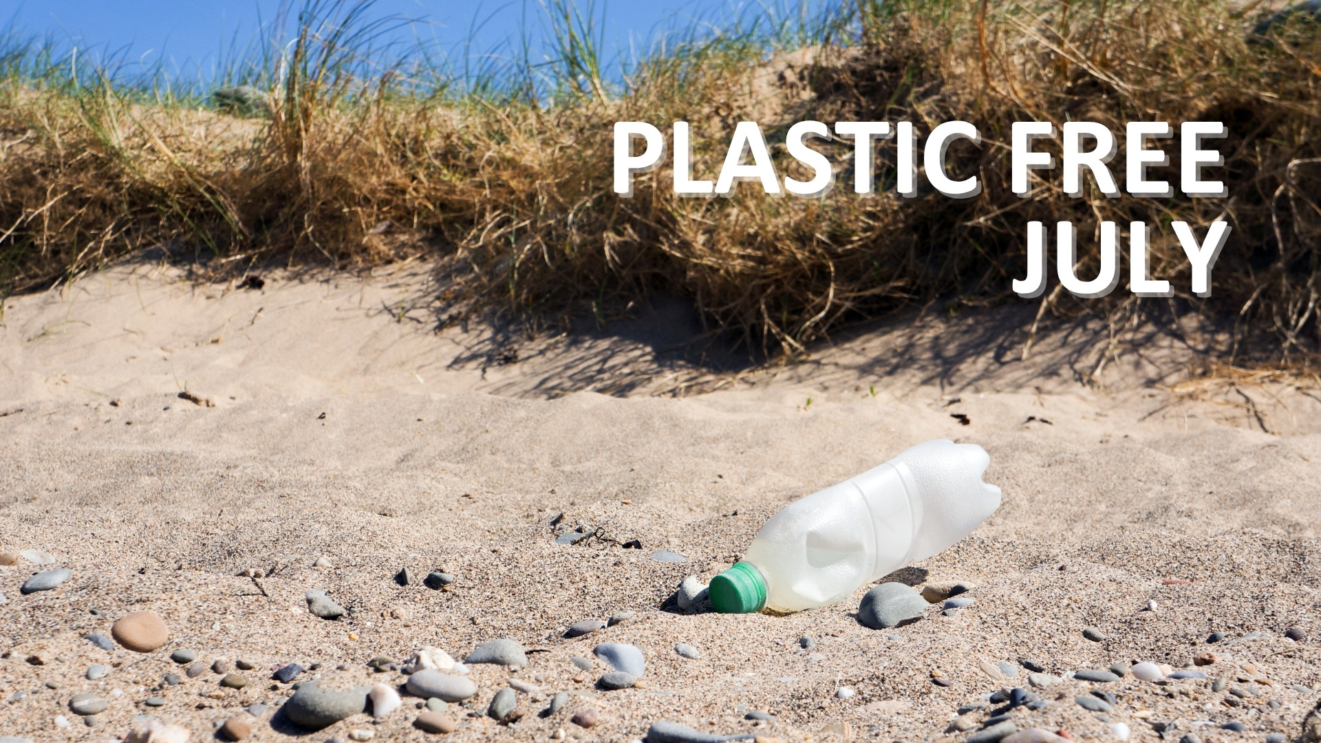 A discarded plastic bottle on a beach. Text reads "plastic free July"