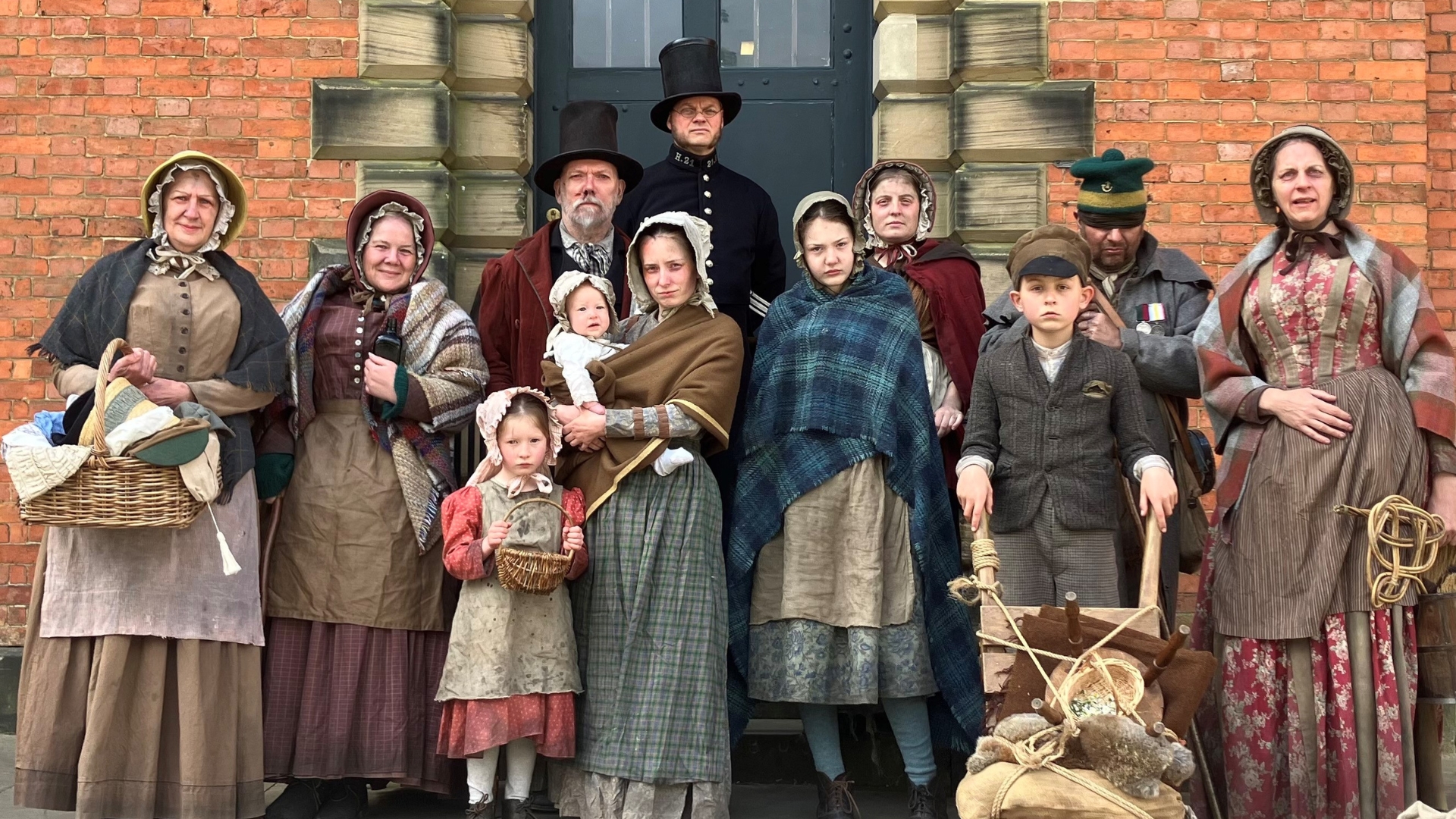 The Ragged Victorians cast in traditional costume stood outside the entrance to Lincoln Castle's Victorian Prison