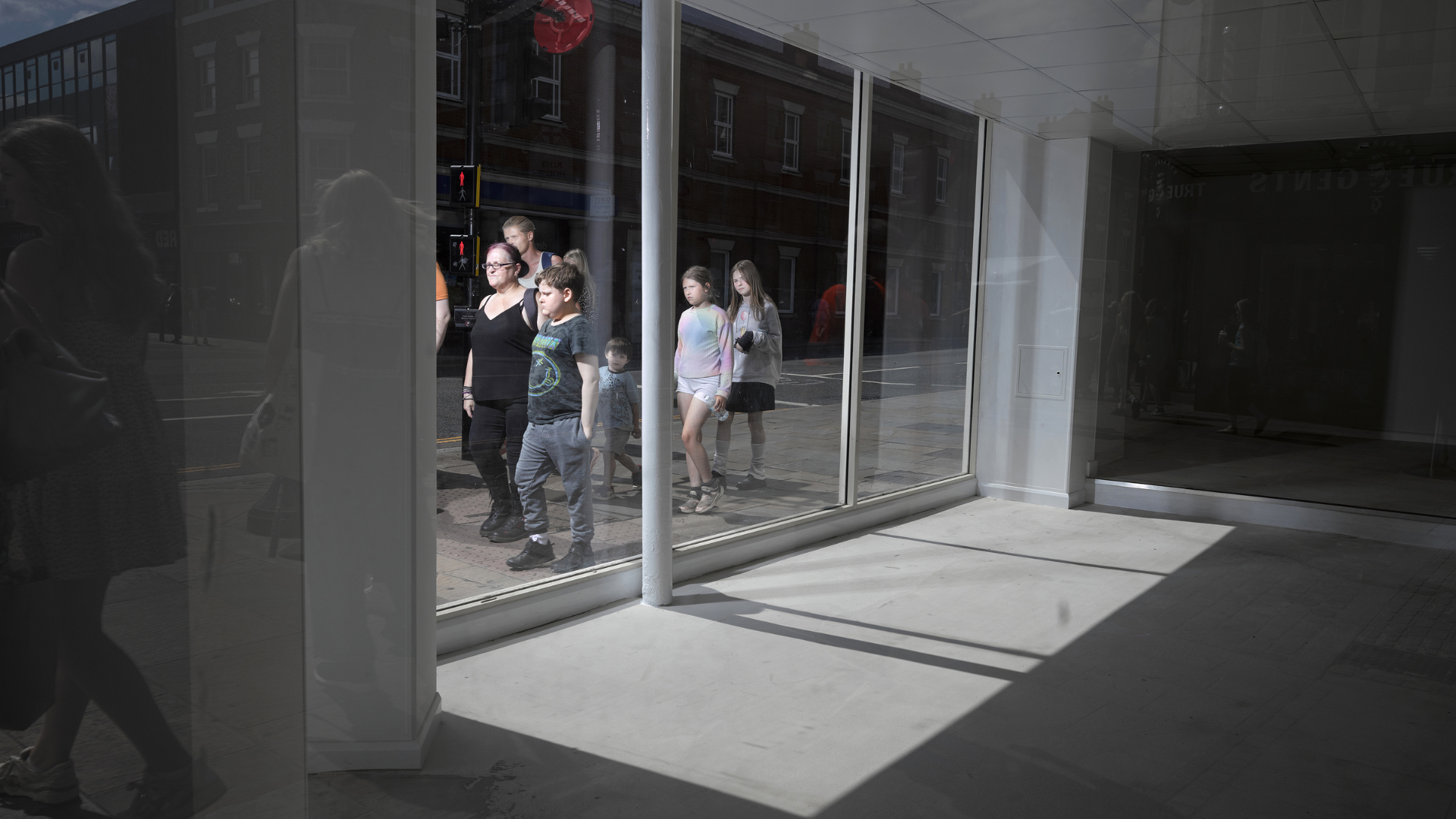 People passing by a shop window on Lincoln High Street, by Richard Ansett