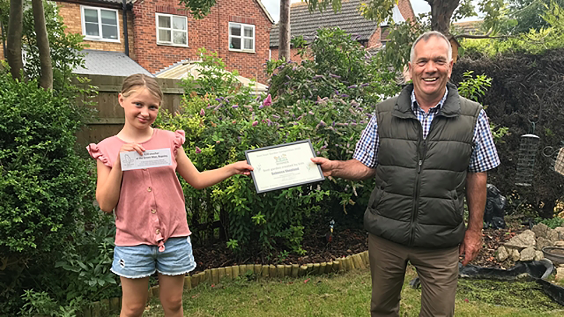 Garden expert John Stirland presents a certificate to Rebecca Shopland, winner of the Best Garden Created by Kids category in the Ropsley online garden competition