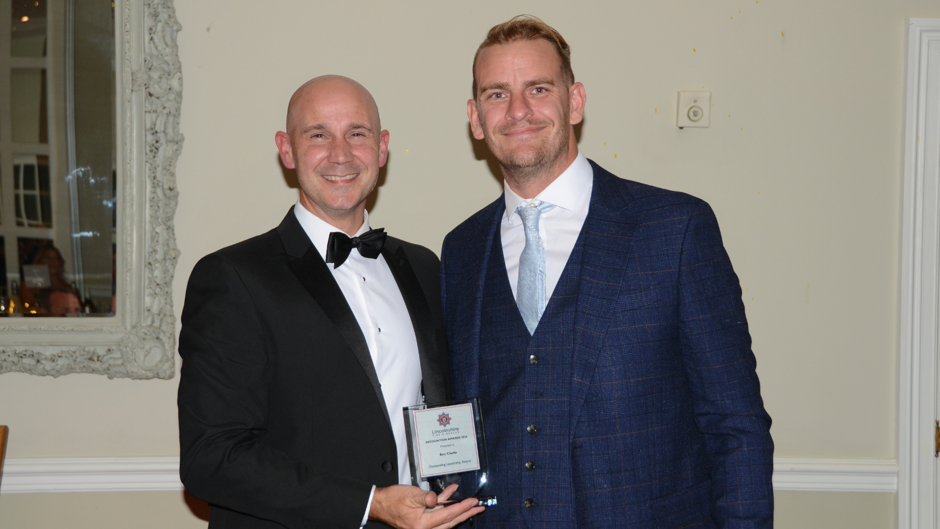 Two men posing with award