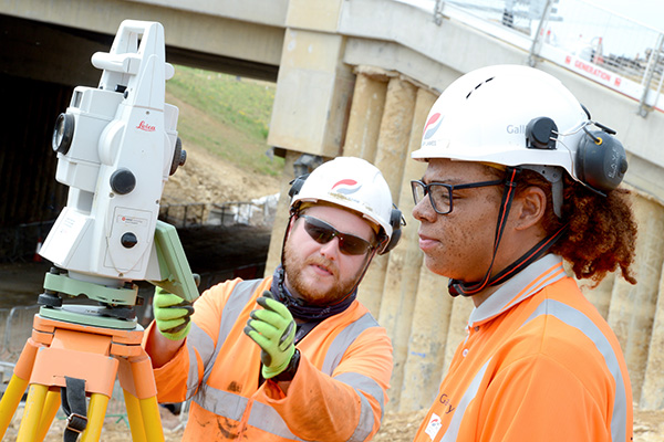 Apprenctice engineer being taught to use specific machinery