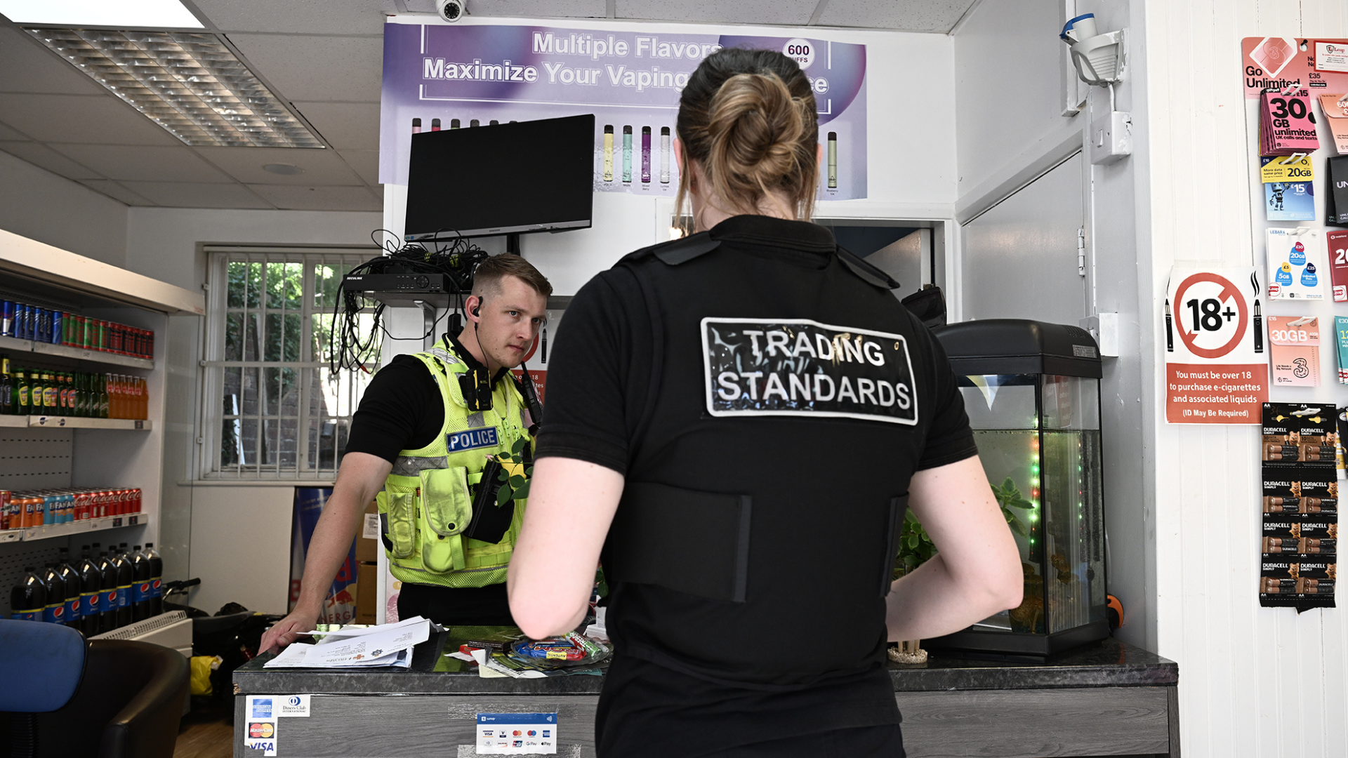 Trading standards and a police officer stood in a shop