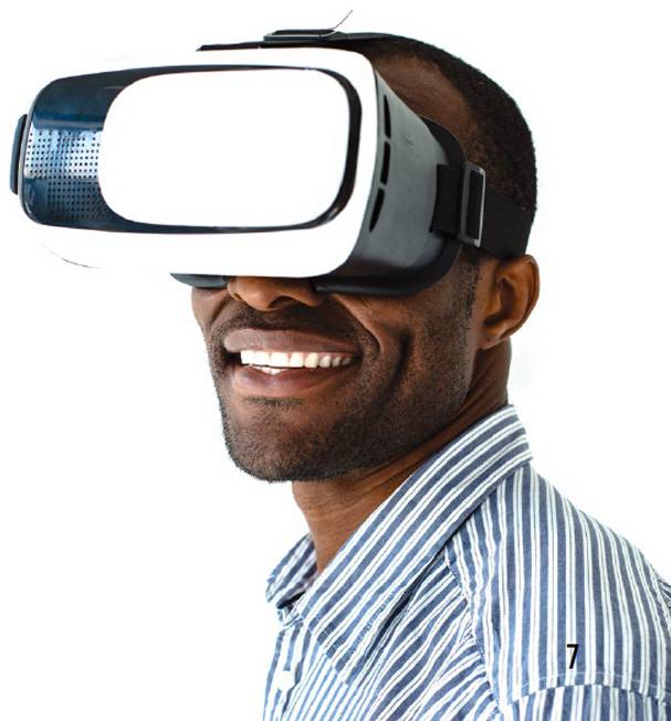 A man wearing virtual reality goggles and smiling