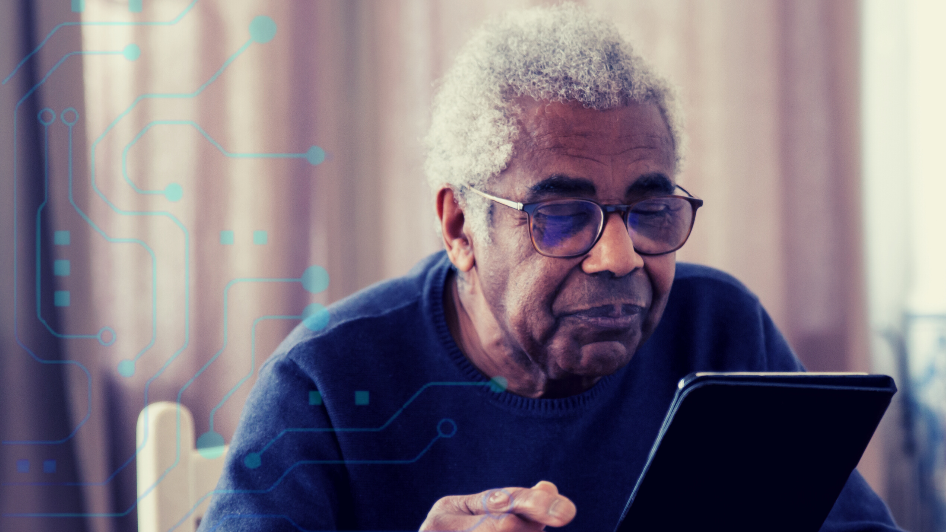 An elderly man reading from a electronic tablet.