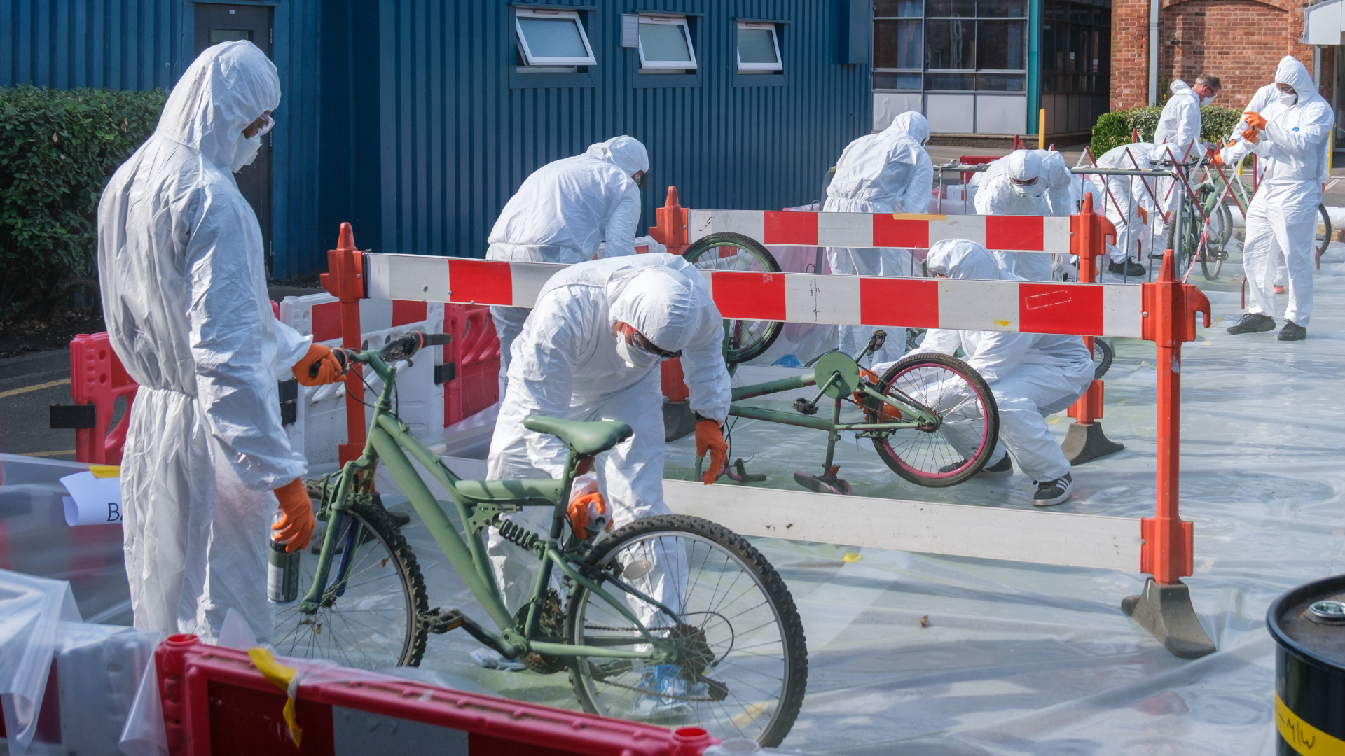 teams of people spray painting bikes green