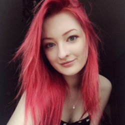A young woman with pale skin and bright read hair taking a selfie