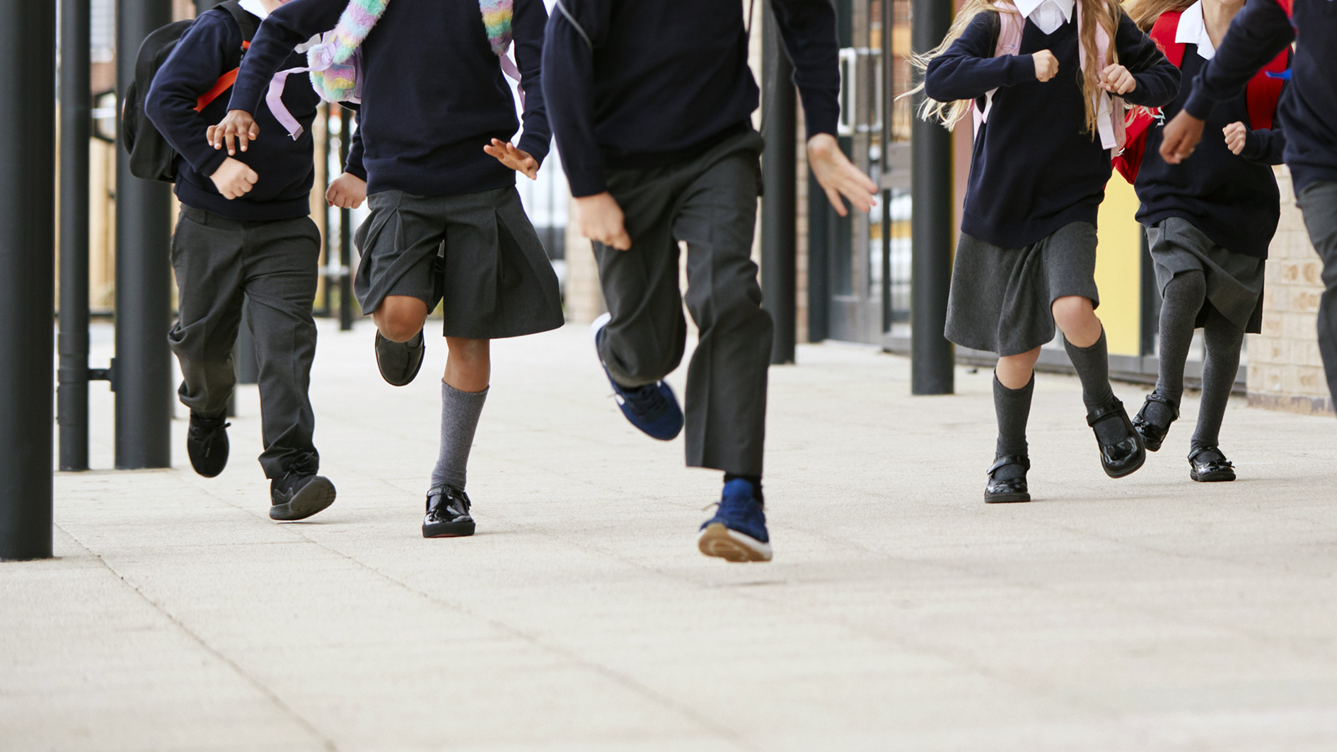 Small children running across a school yard