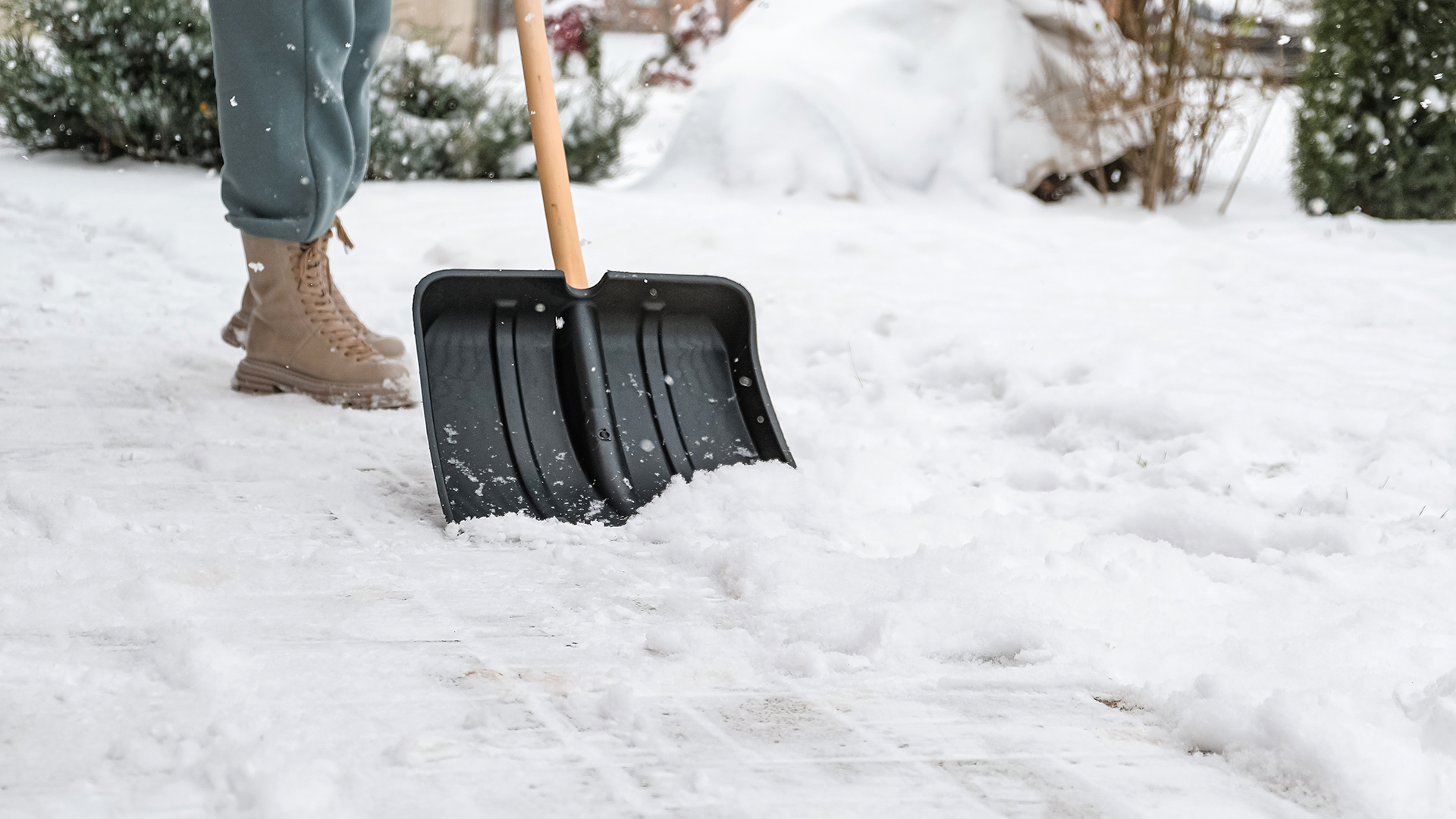 Close up of a woman cleaning and clearing snow