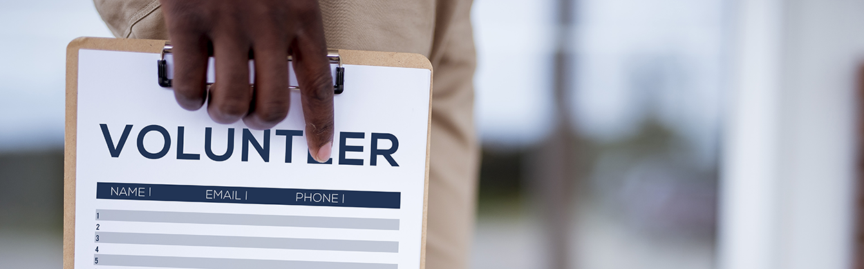 Image of a person holding a volunteer sign