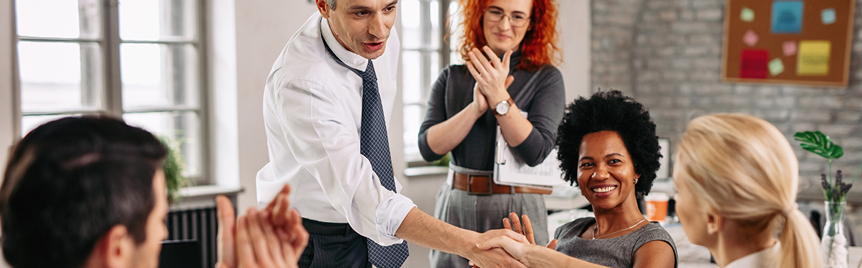 Image of a man and woman shaking hands at work