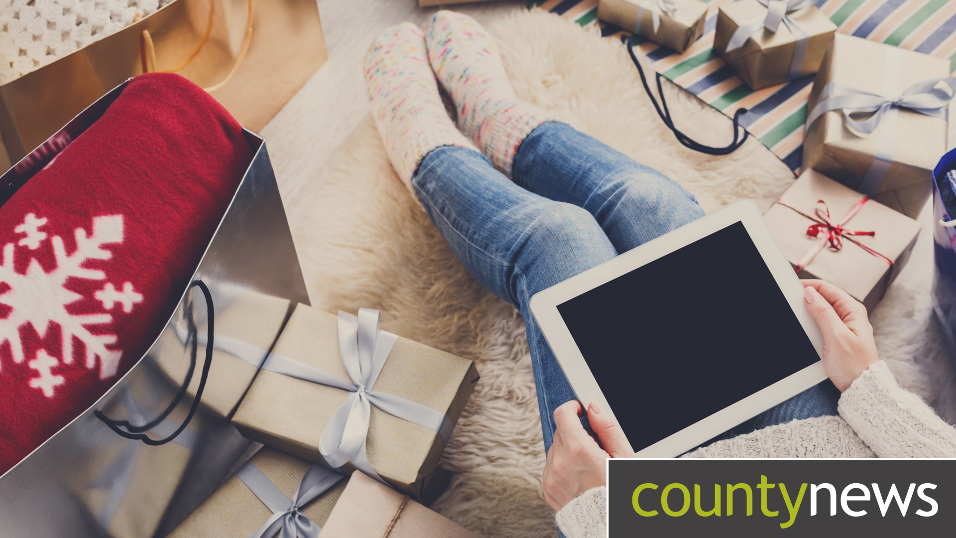 Image of a woman sat with tablet Christmas shopping.