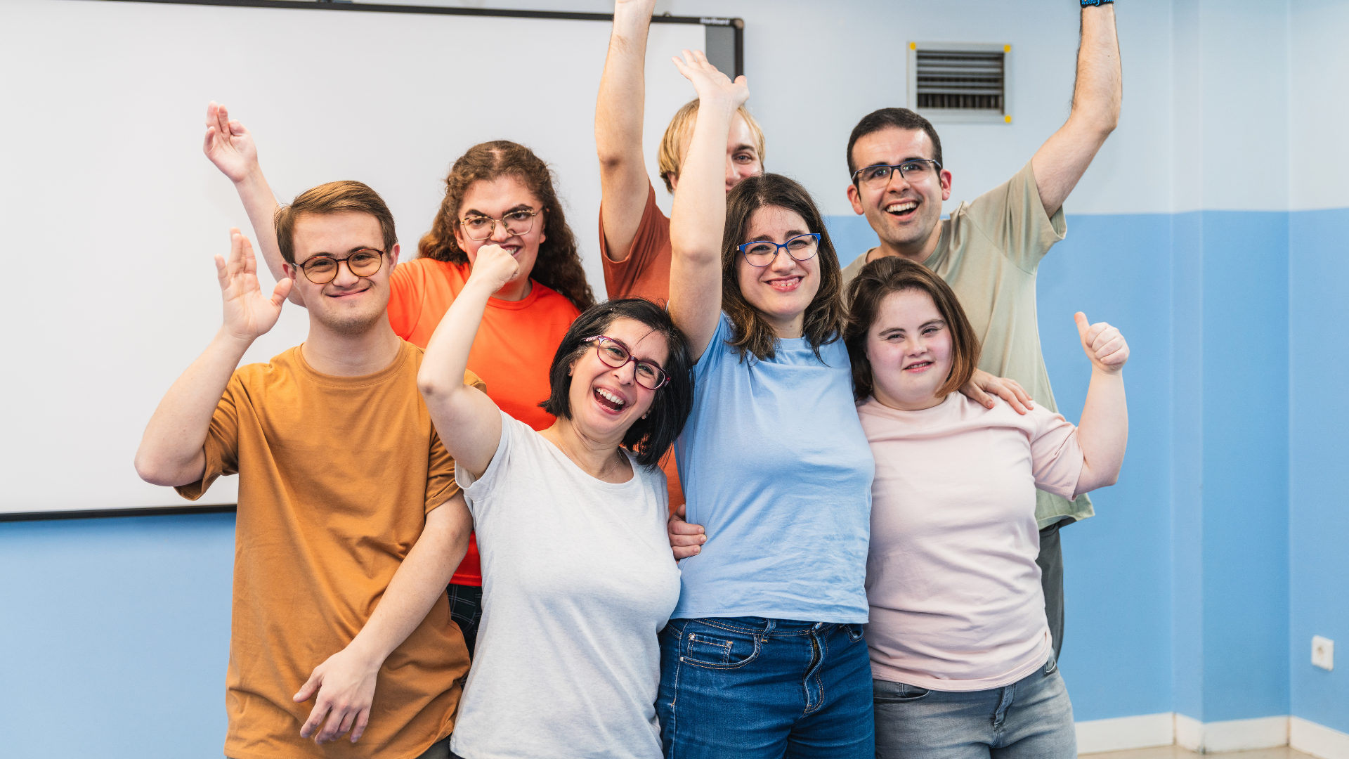 Enthusiastic group celebrates with raised arms and smiles