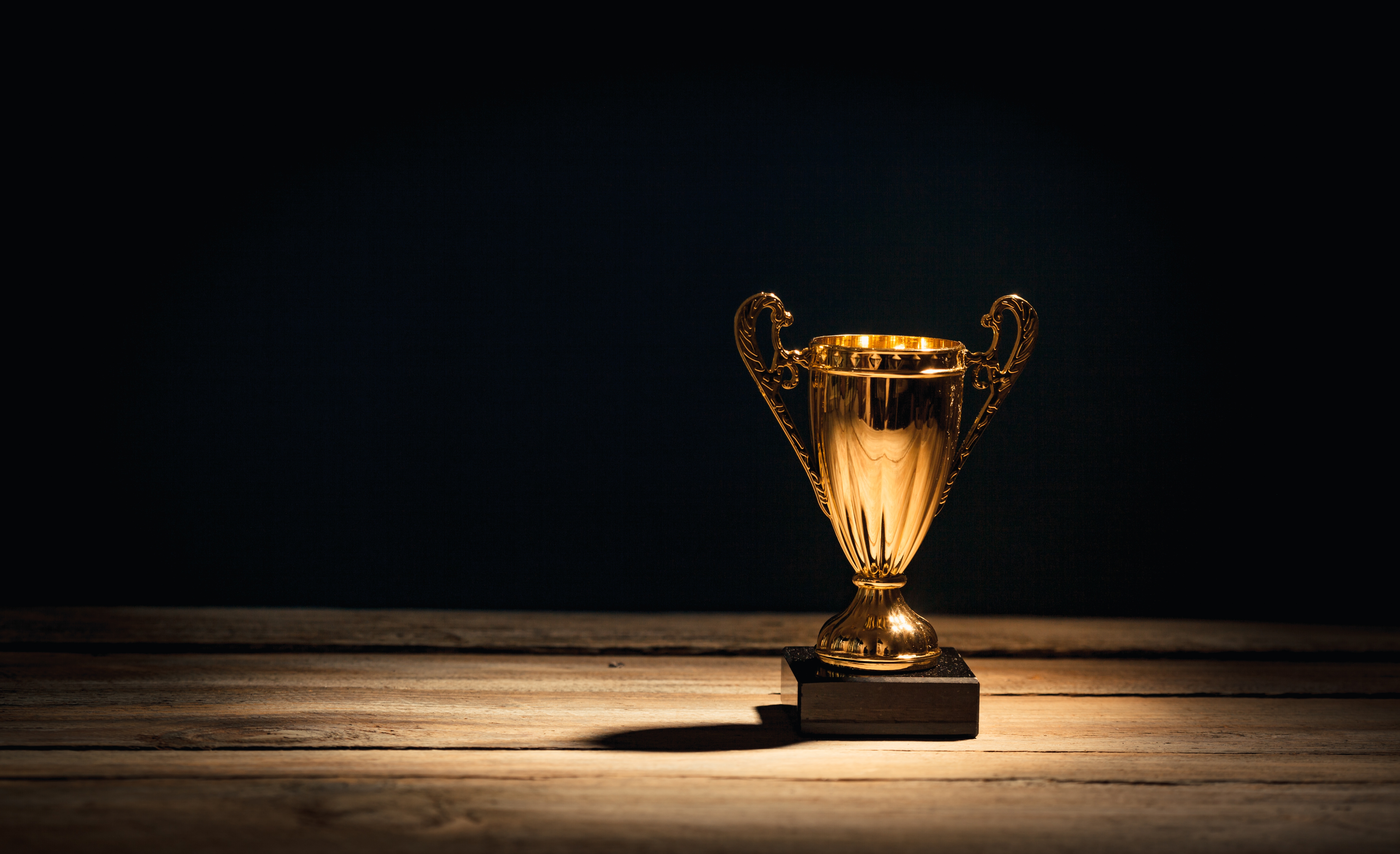 Golden sports trophy cup on wood desk